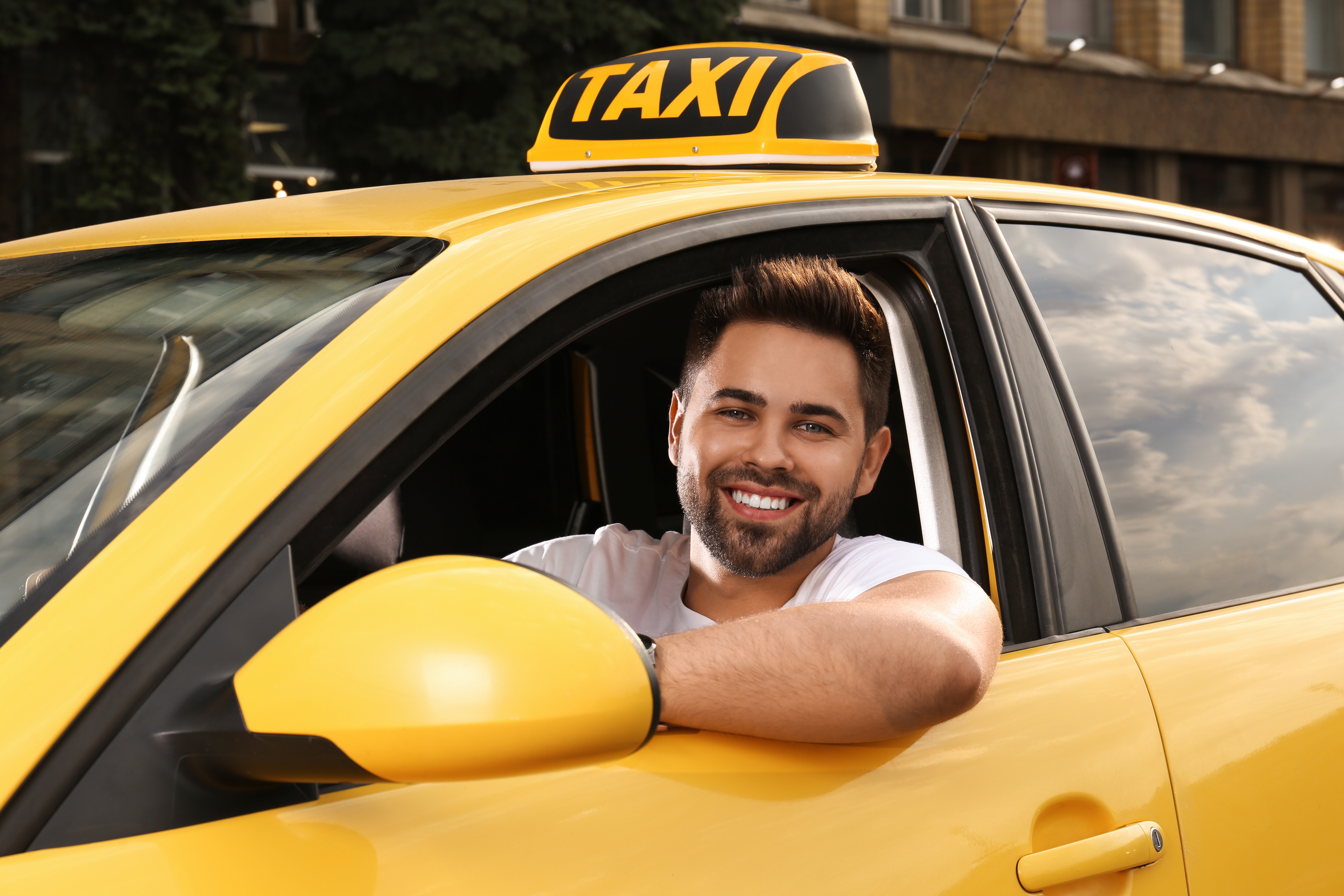 Un chauffeur de taxi masculin dans un taxi jaune | Source : Shutterstock
