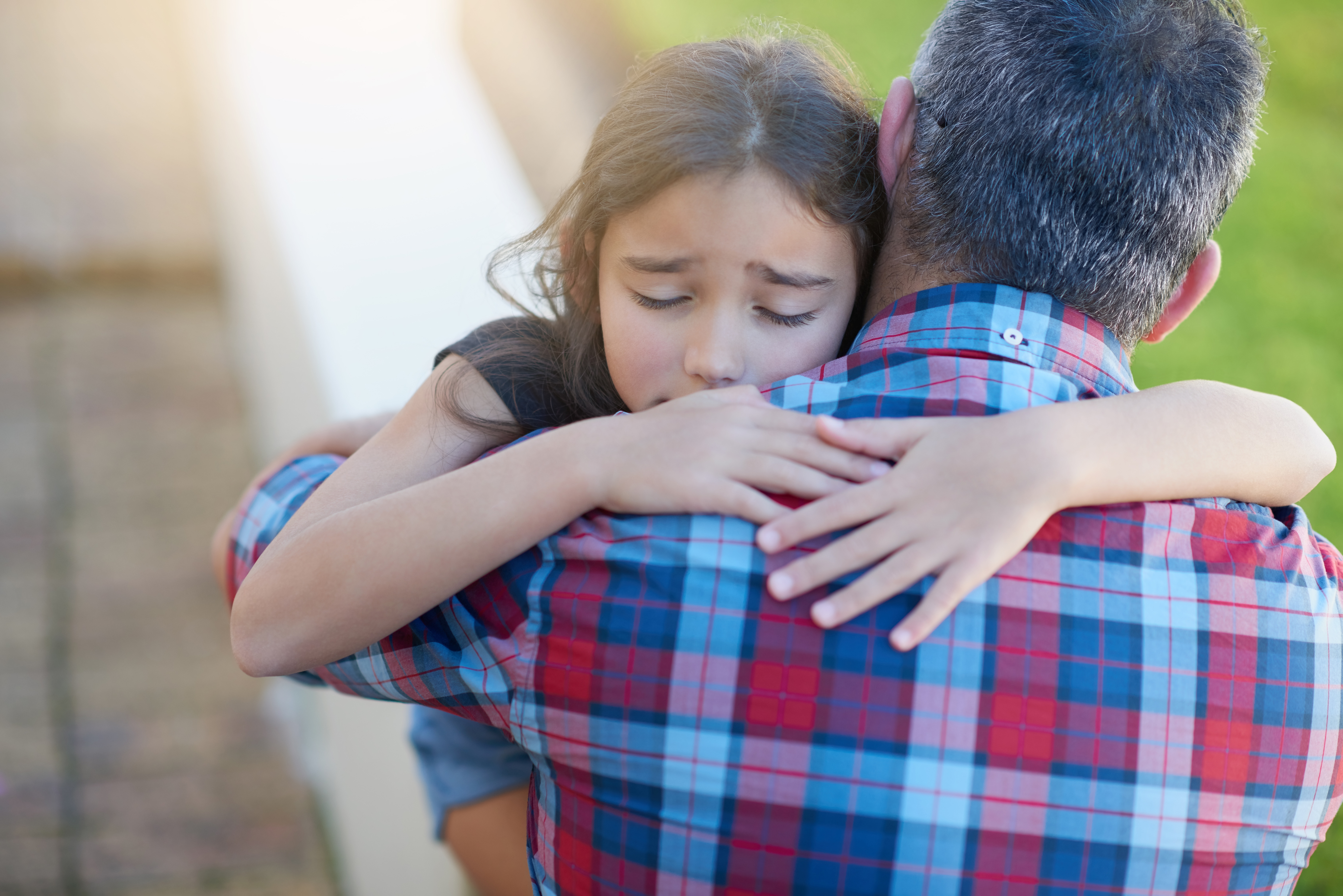Un père réconforte sa jeune fille en détresse | Source : Shutterstock