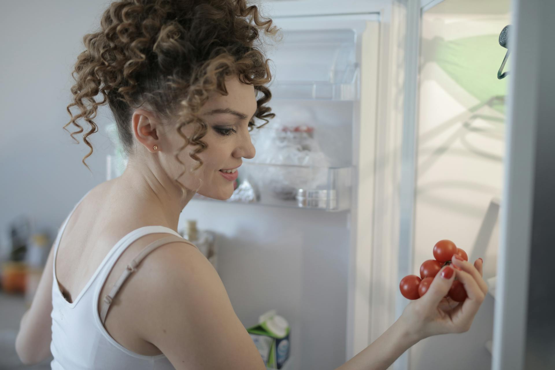 Une femme range la nourriture dans un réfrigérateur | Source : Pexels