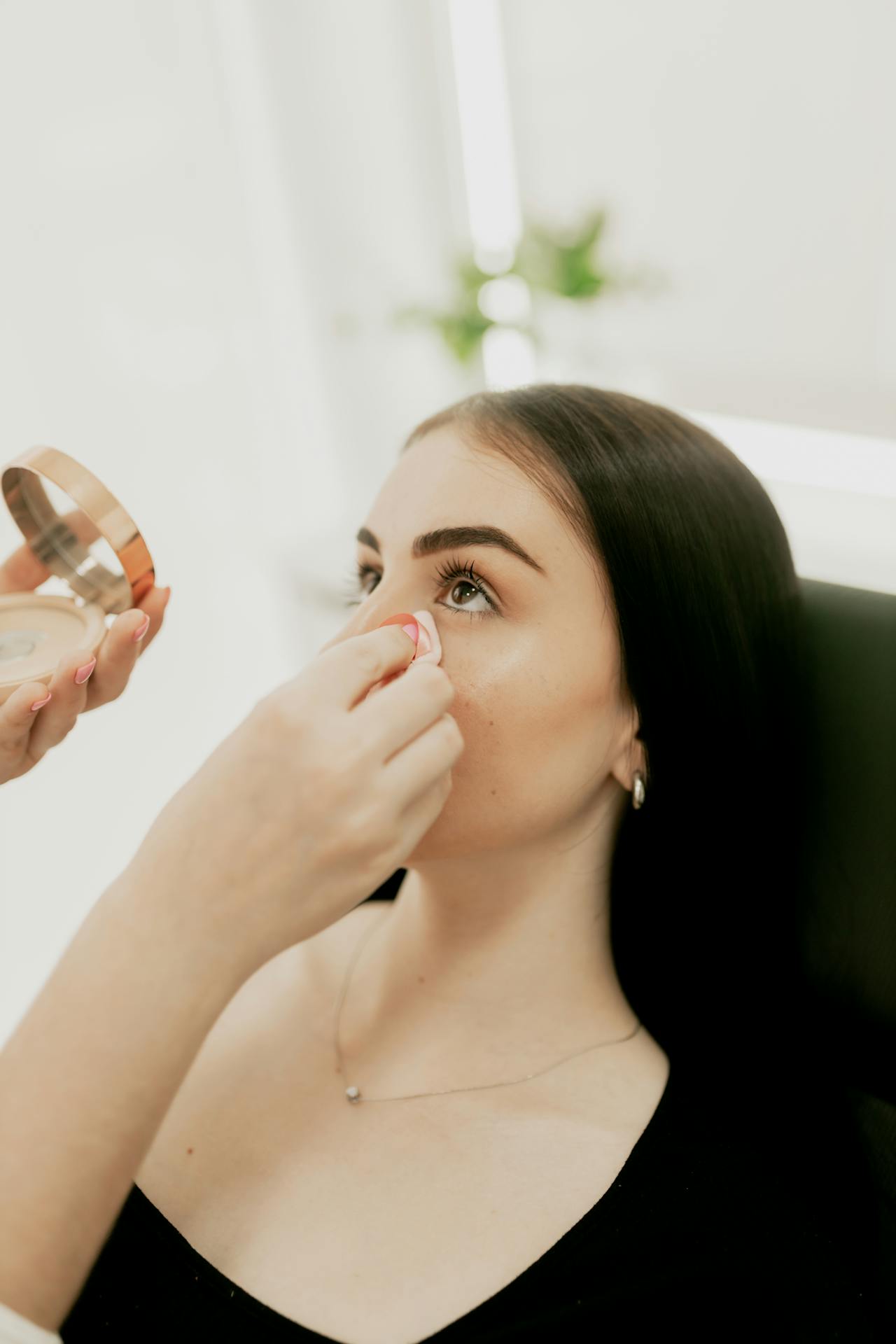 Une femme ajoute une retouche au visage d'une jeune femme | Source : Pexels