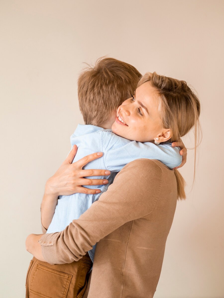 Une femme qui serre son fils dans ses bras | Source : Freepik