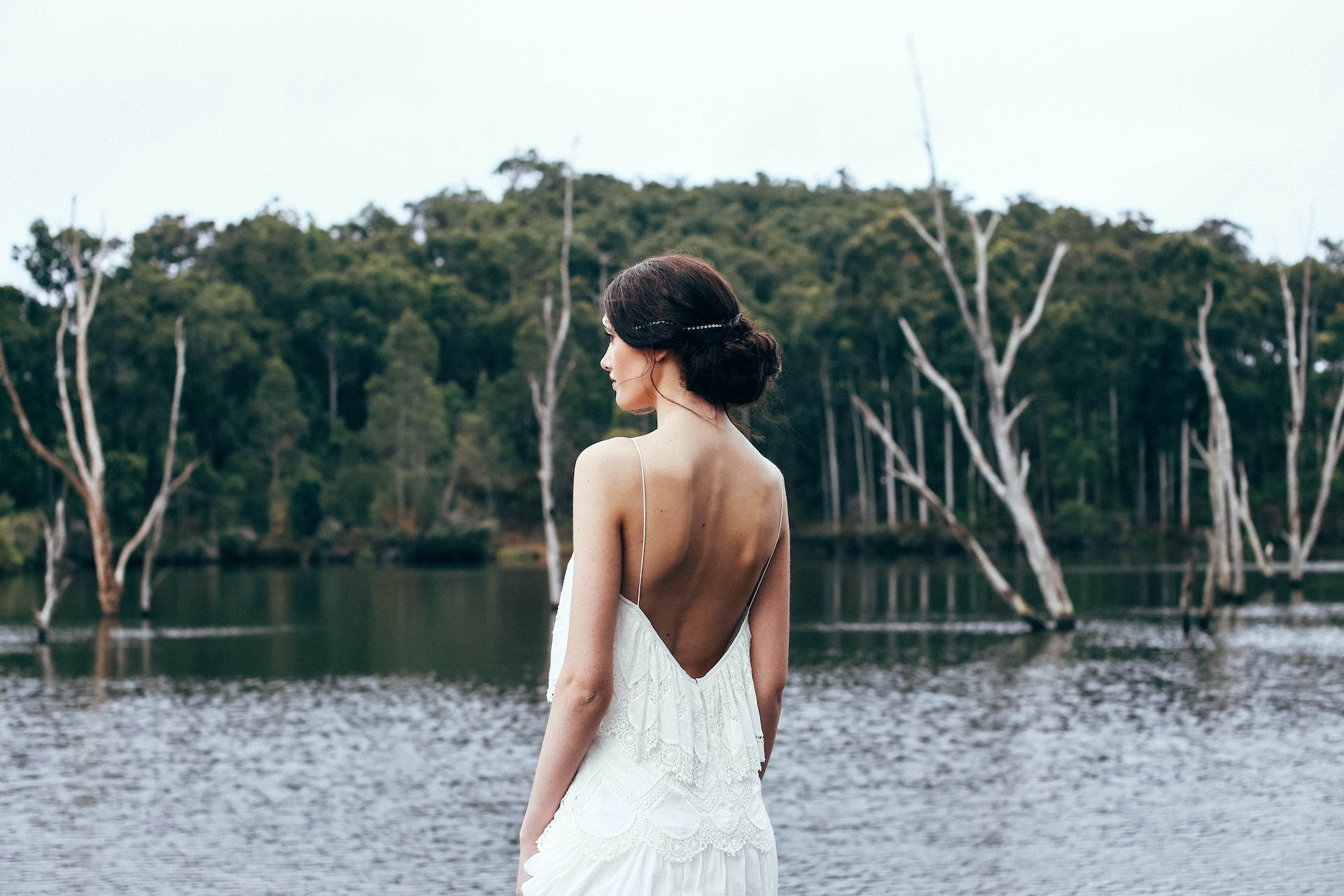 Una novia de pie cerca de un lago | Fuente: Pexels