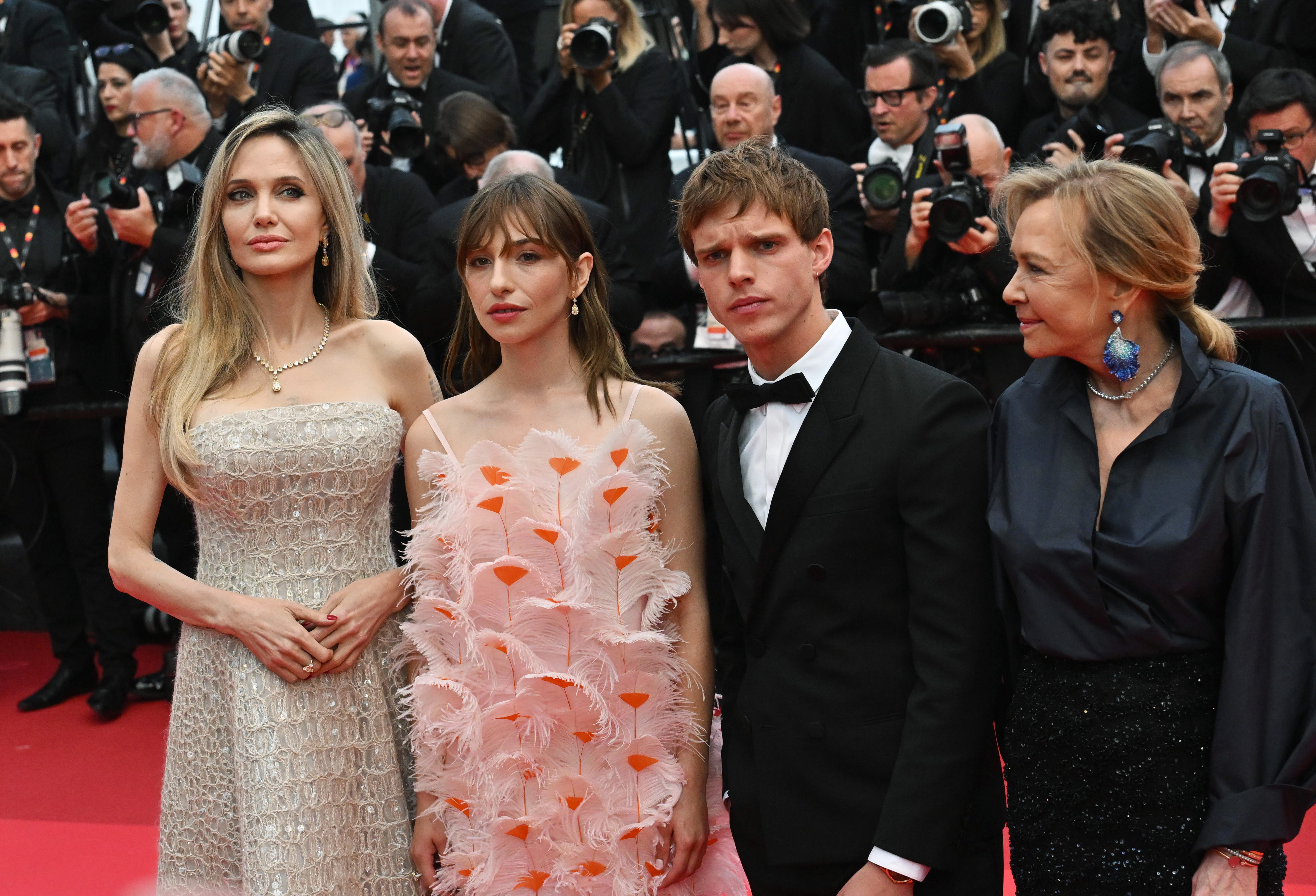 Angelina Jolie pose aux côtés de Marie Colomb, Finn Bennett et Caroline Scheufele lors de la première du film "Eddington". Vêtue d'une robe de bal champagne étincelante, Angelina Jolie apporte un glamour raffiné à ce portrait de groupe au milieu d'une tempête de flashs d'appareil photo