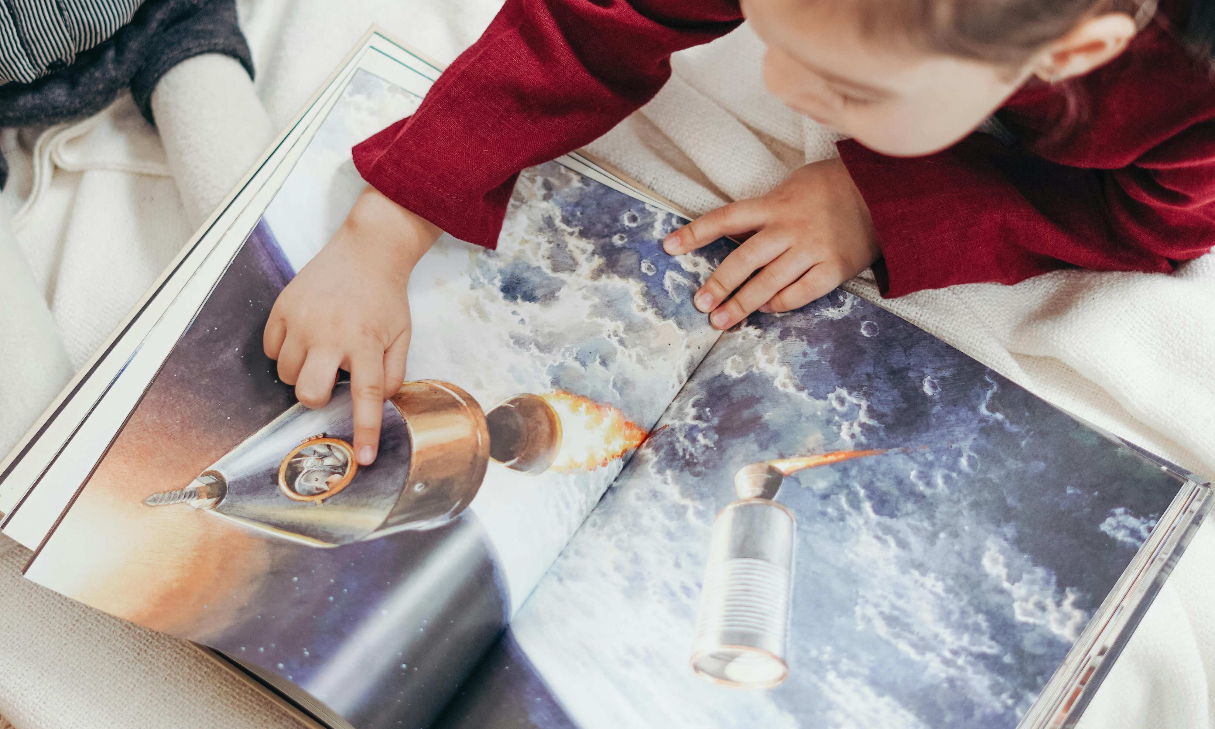 Un bébé explore un livre | Source : Pexels