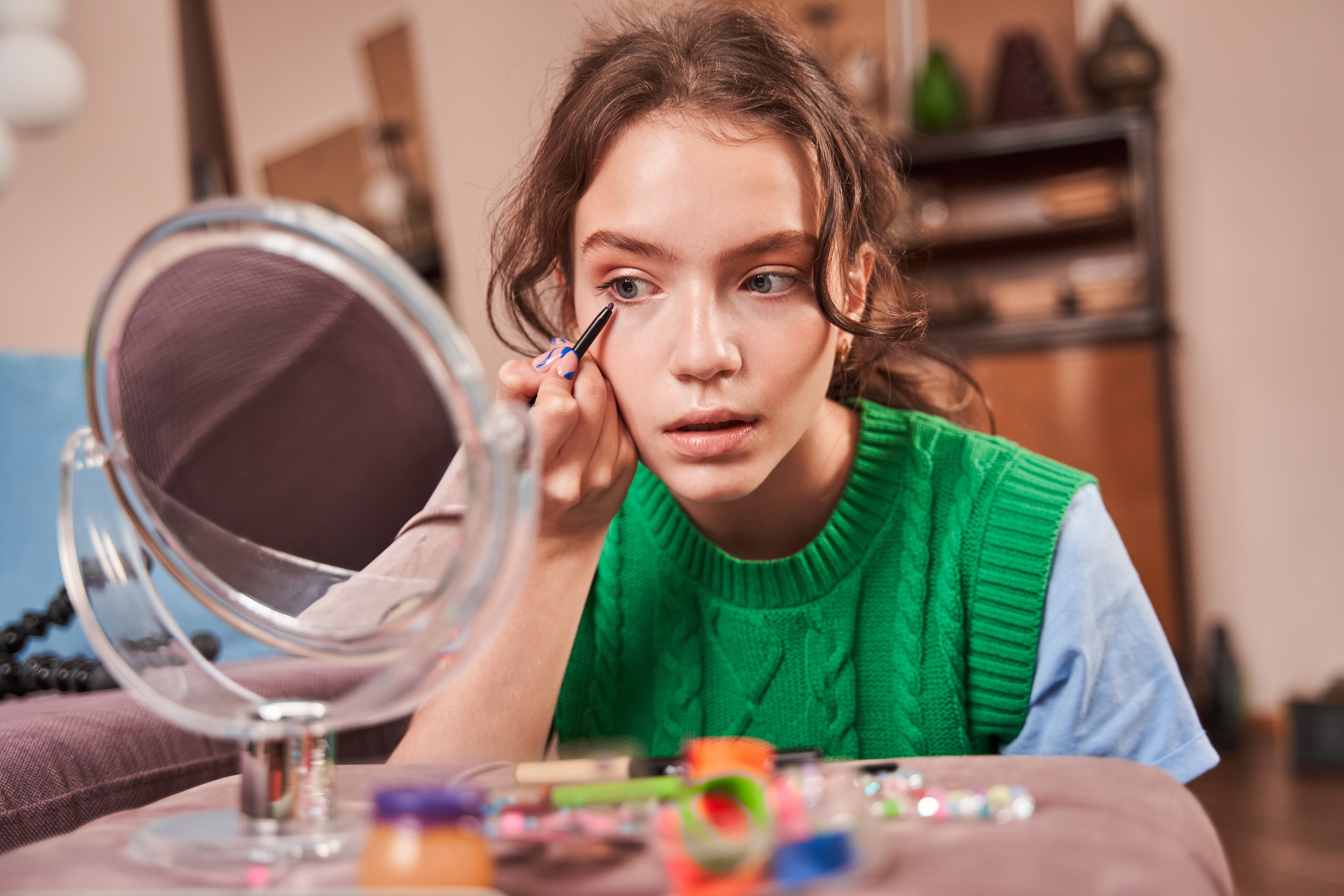 Une adolescente se maquille en se regardant dans le miroir | Source : Shutterstock