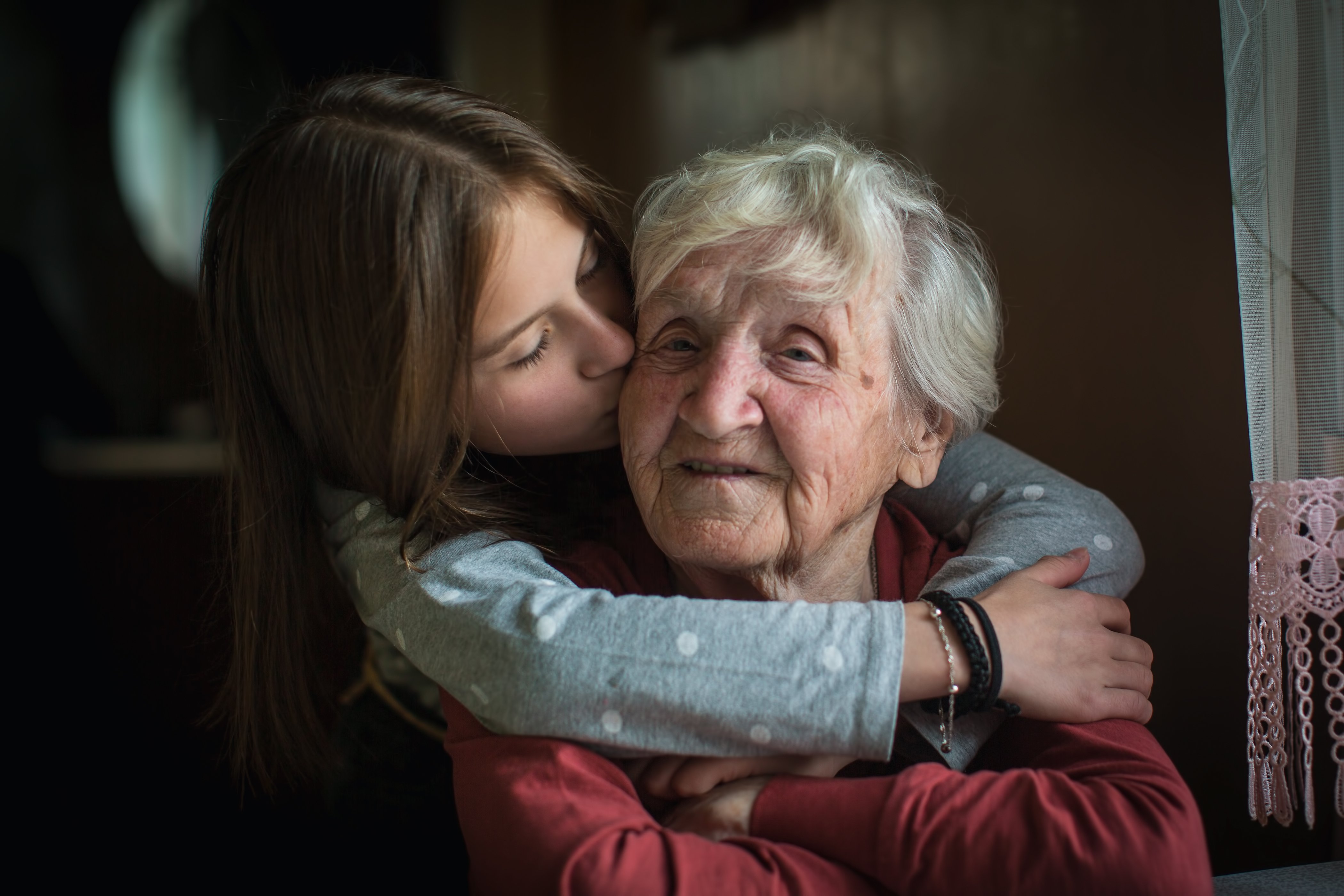 Une petite fille embrasse sa grand-mère. | Photo : Shutterstock