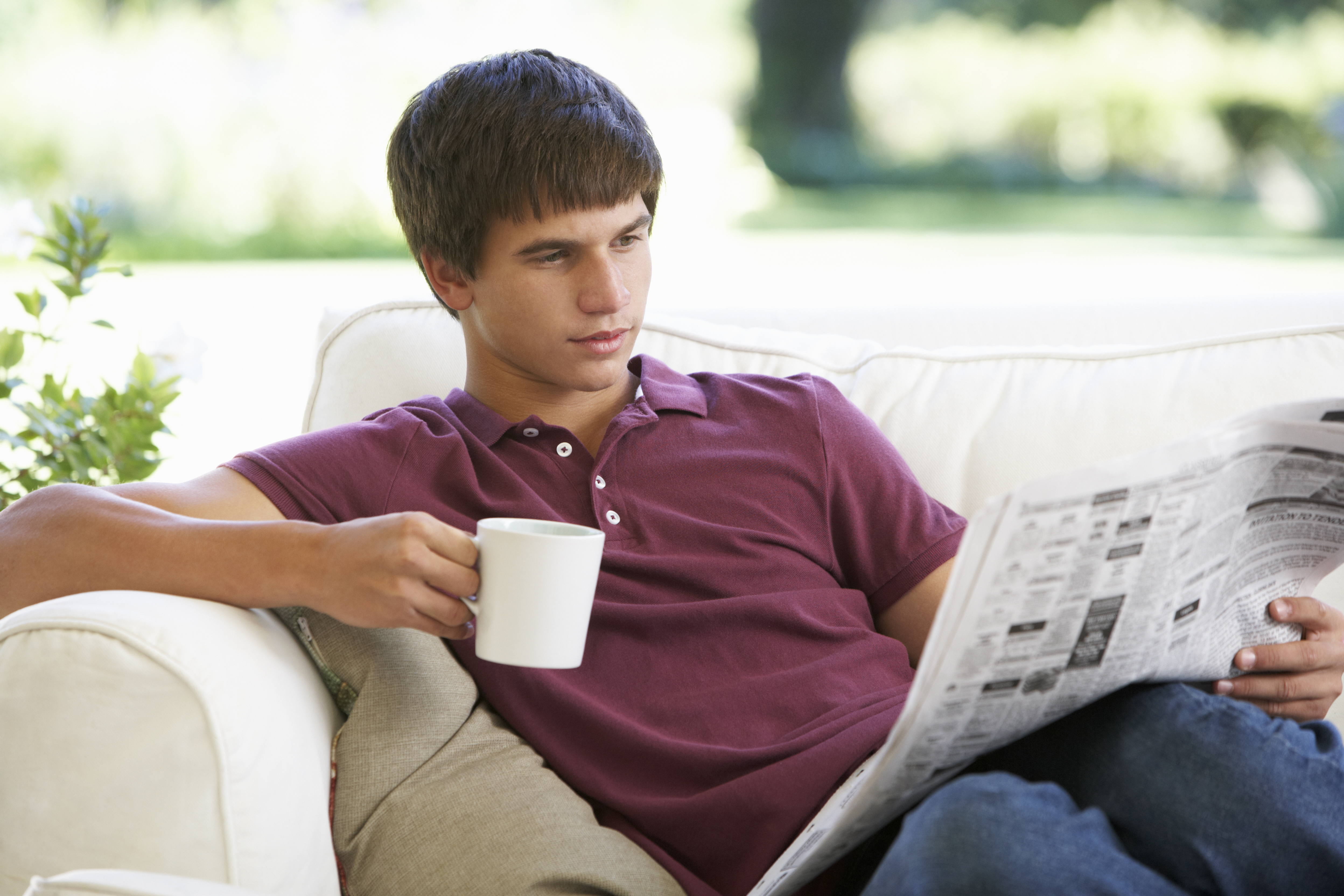 Un adolescent lit un journal | Source : Shutterstock