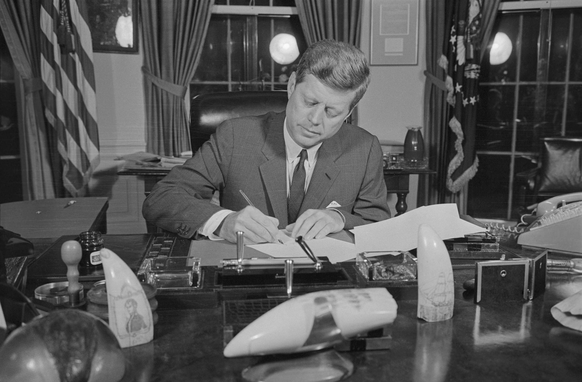 L'ancien président John F. Kennedy signant l'ordre de blocus dans son bureau en 1962. | Source : Getty Images