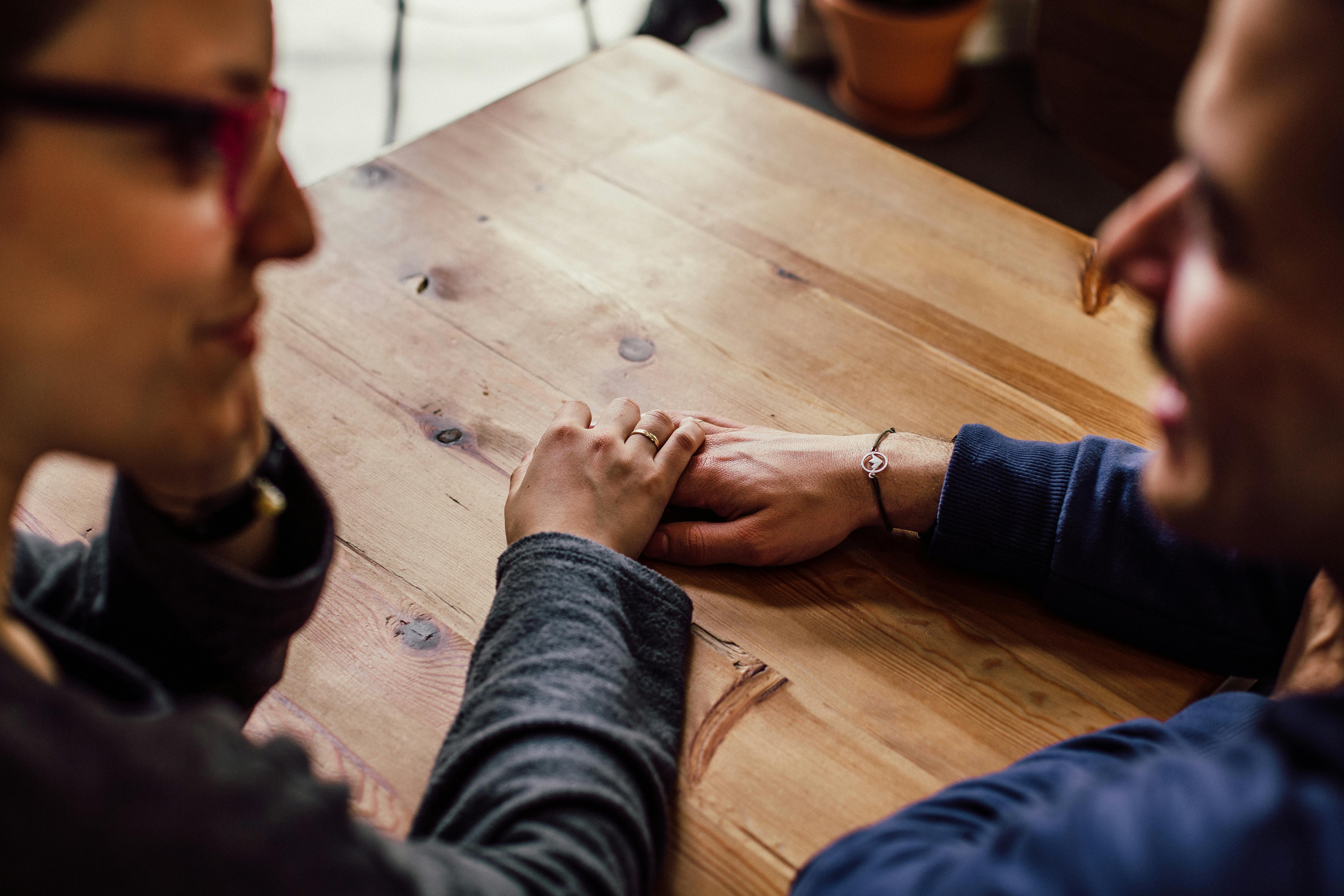 Un couple ayant une conversation profonde tout en se touchant les mains | Source : Pexels