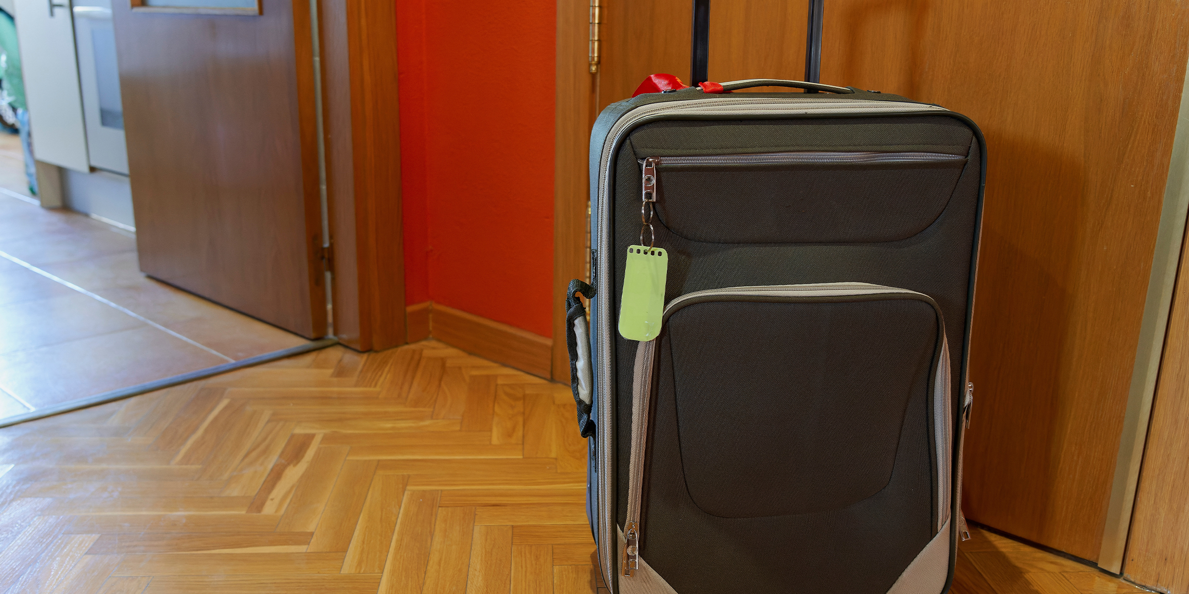 Une valise placée devant la porte d'entrée d'un appartement | Source : Shutterstock