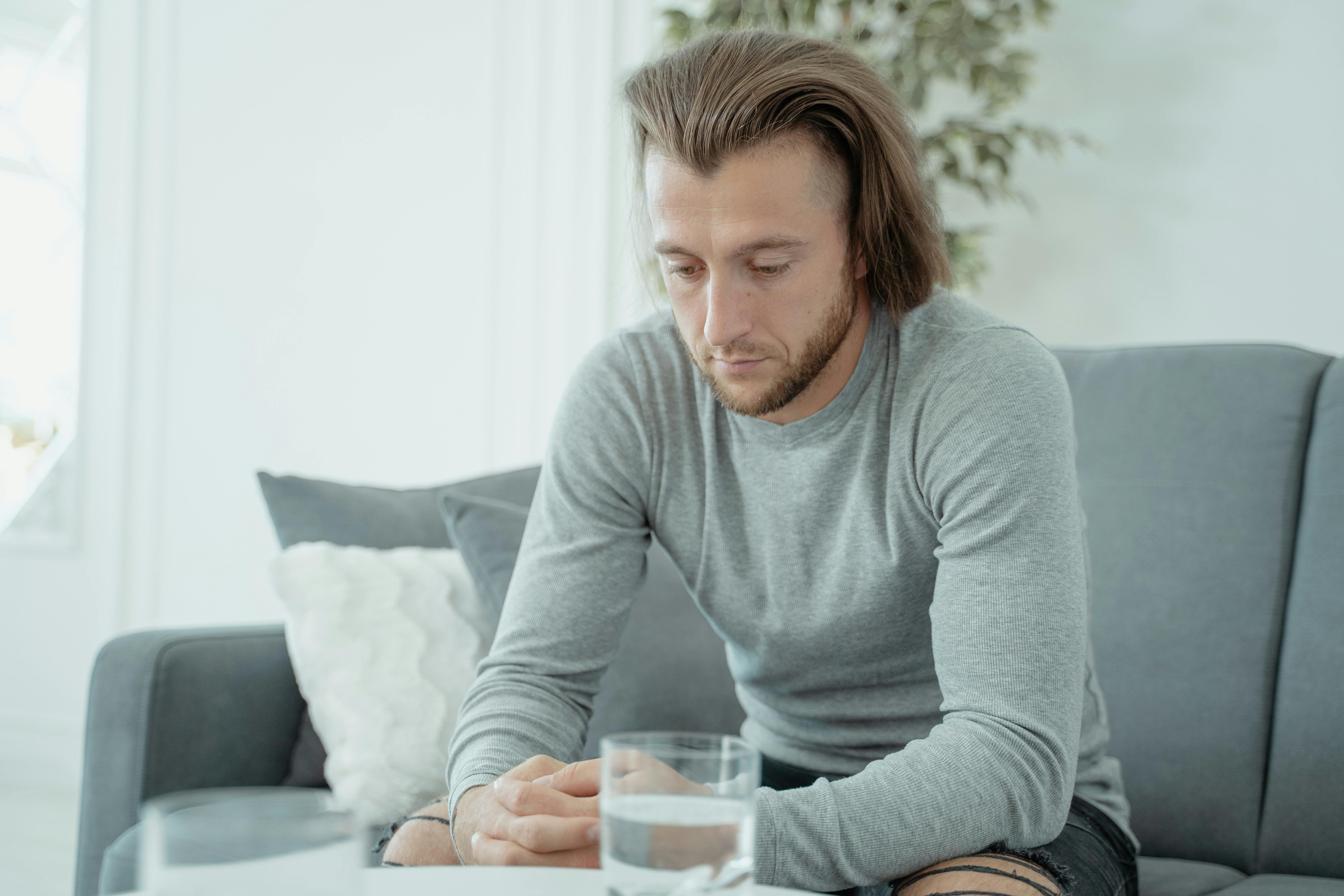 Un homme assis sur un canapé | Source : Pexels