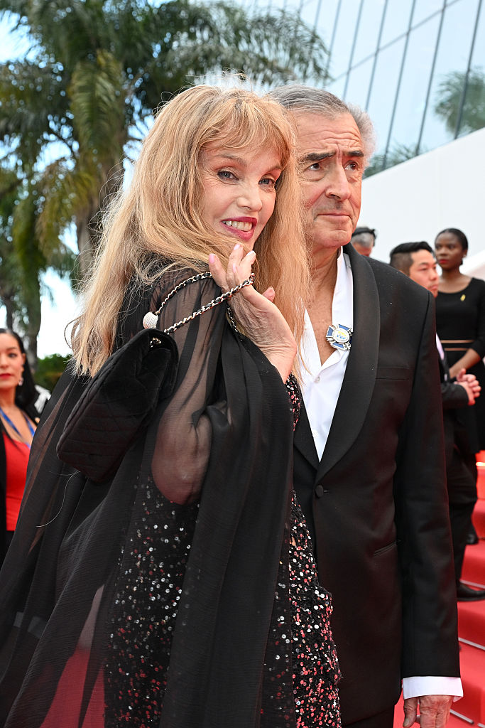 Arielle Dombasle et Bernard-Henri Lévy montent sur le tapis rouge de la cérémonie d'ouverture et de la projection de "Partir un jour" au 78e Festival de Cannes, le 13 mai 2025. | Source : Getty Images