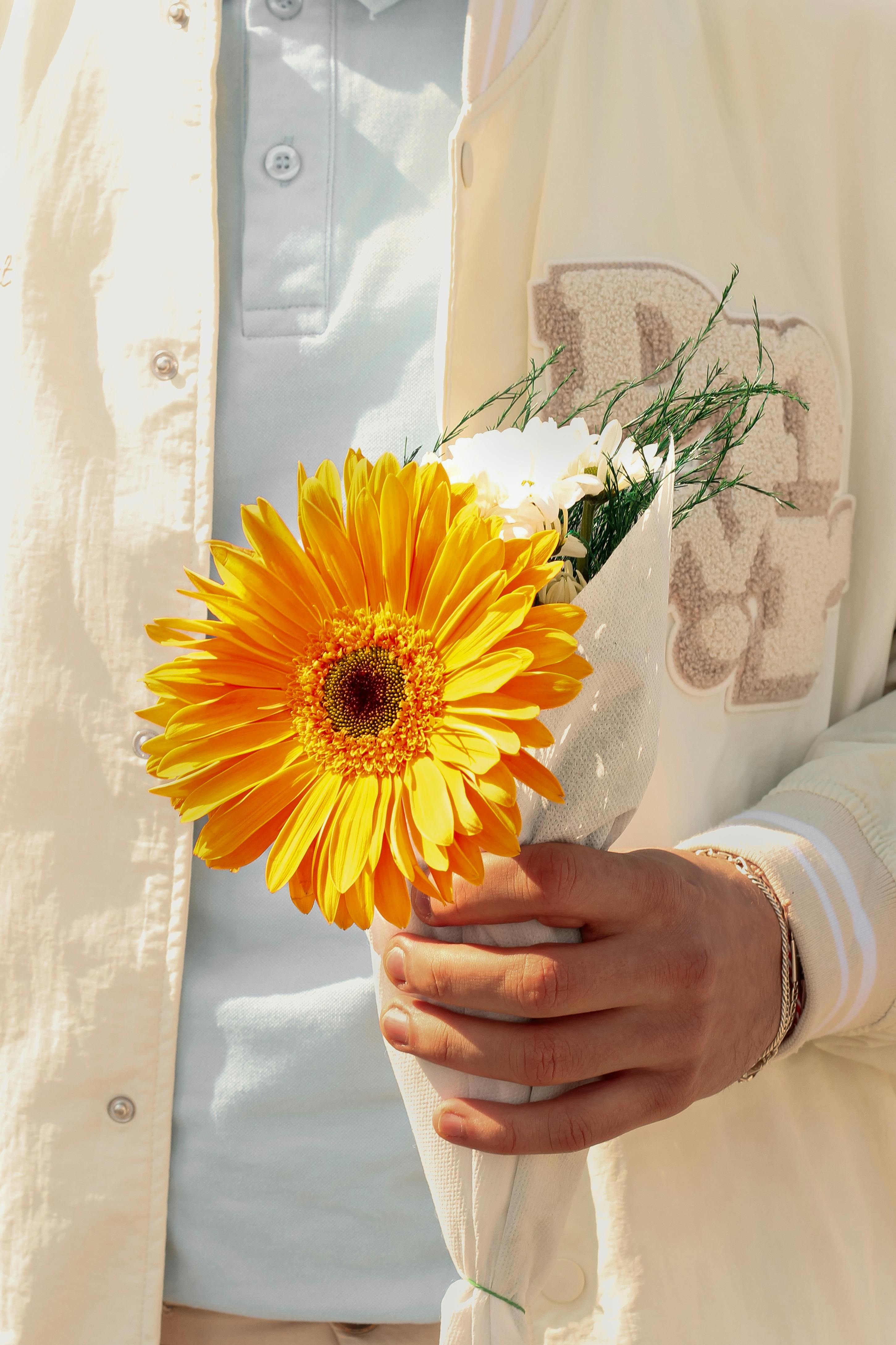 Un homme tenant des fleurs | Source : Pexels