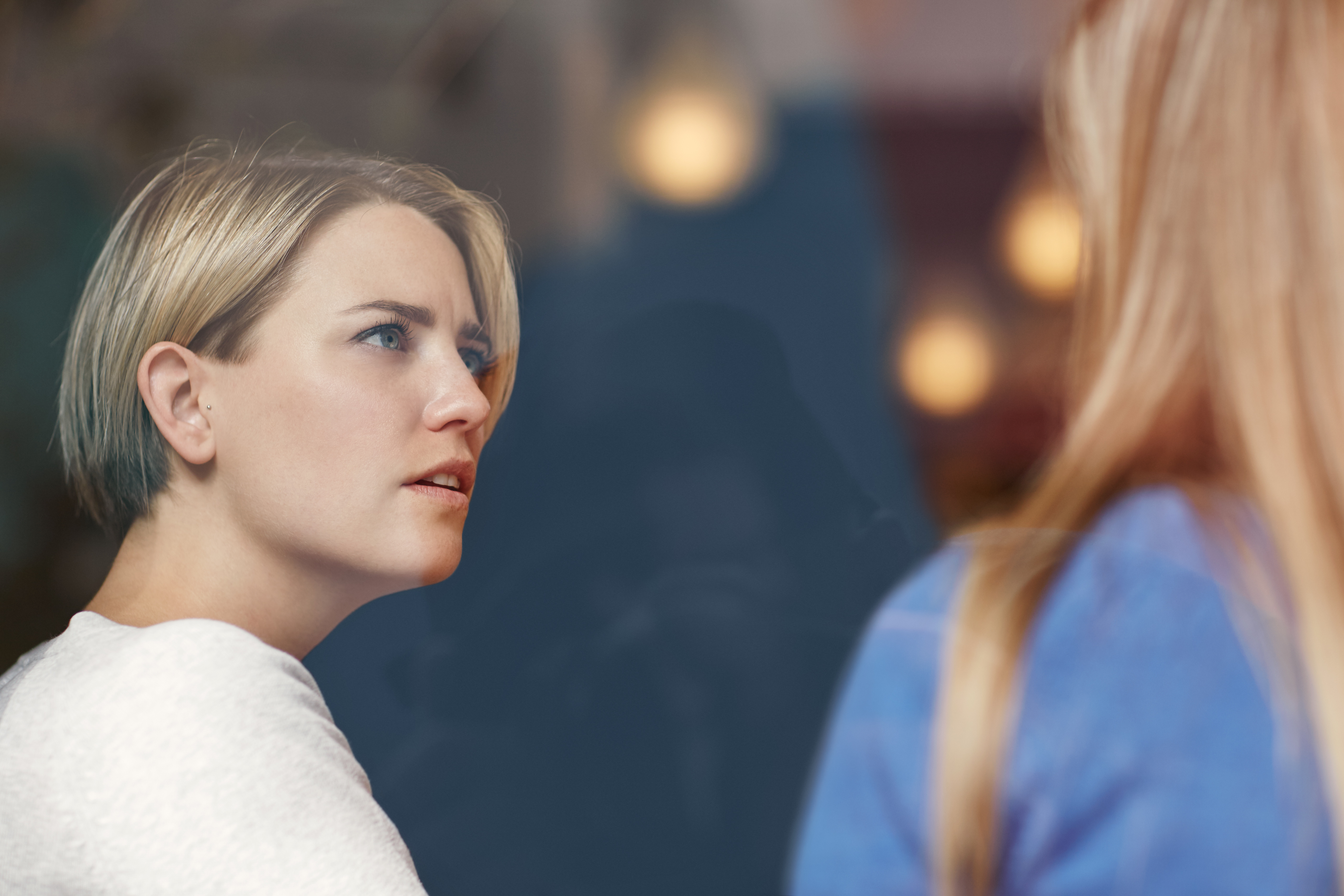 Une femme choquée tout en écoutant une autre femme | Source : Shutterstock