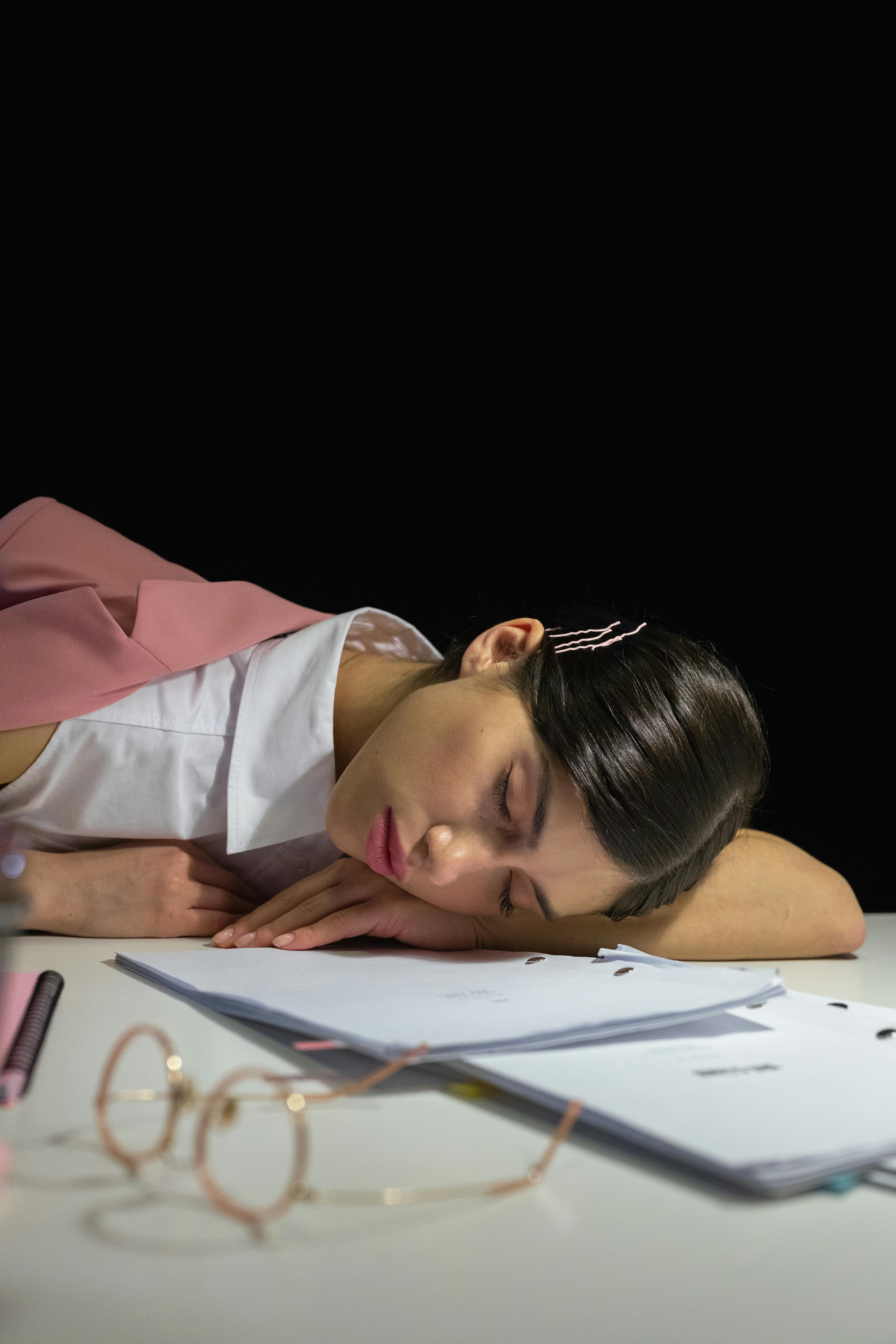 Une femme fatiguée qui dort sur son bureau | Source : Pexels