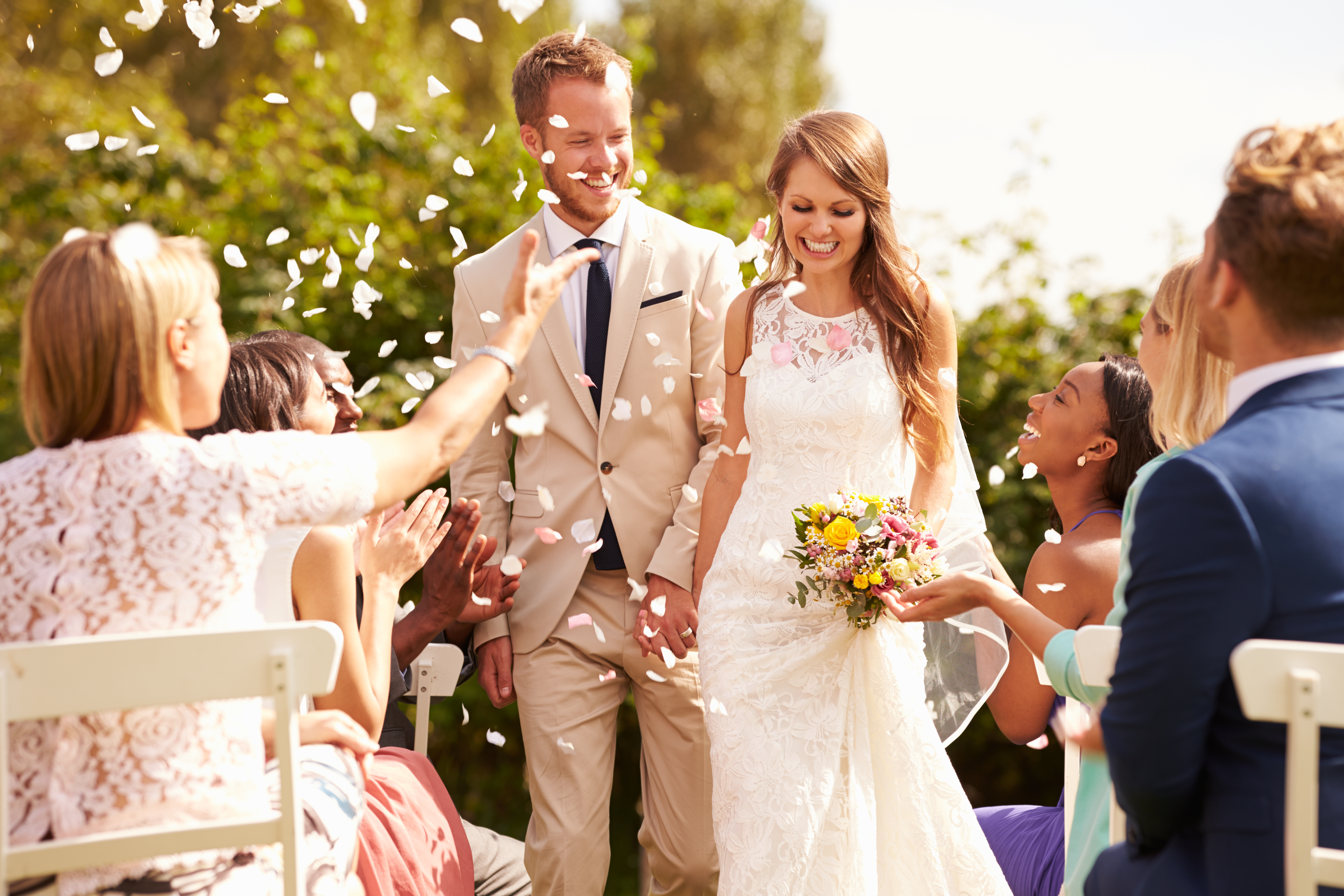 Invités de mariage jetant des confettis sur un couple nouvellement marié | Source : Shutterstock