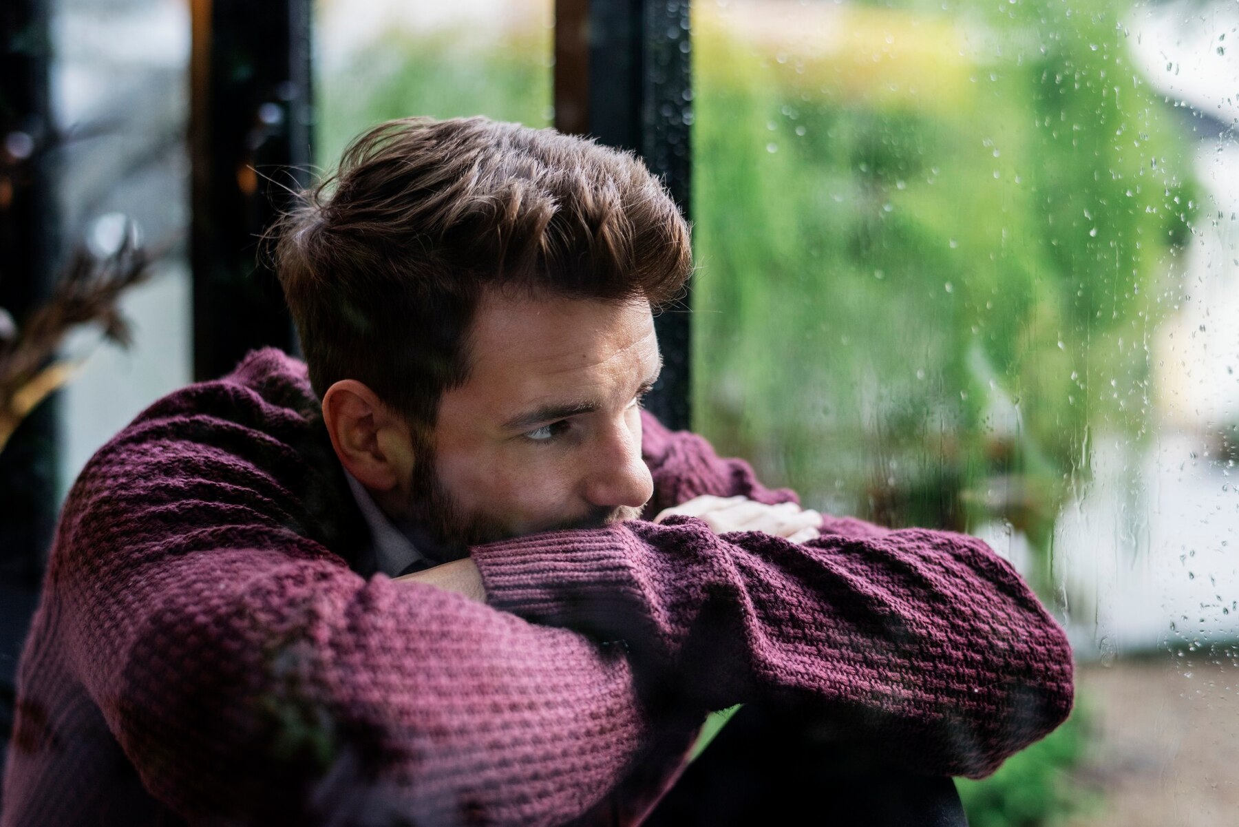 Un homme triste qui regarde par la fenêtre | Source : Freepik