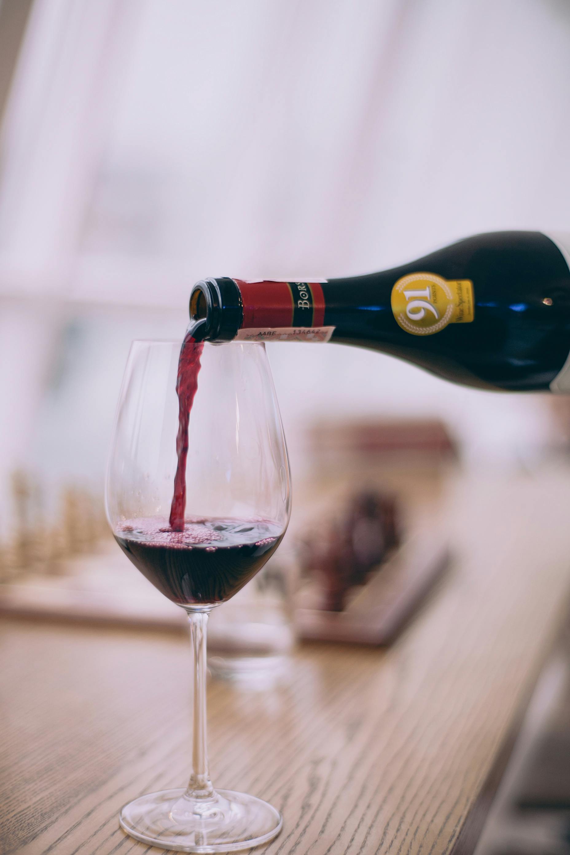 Vin rouge versé dans un verre | Source : Pexels