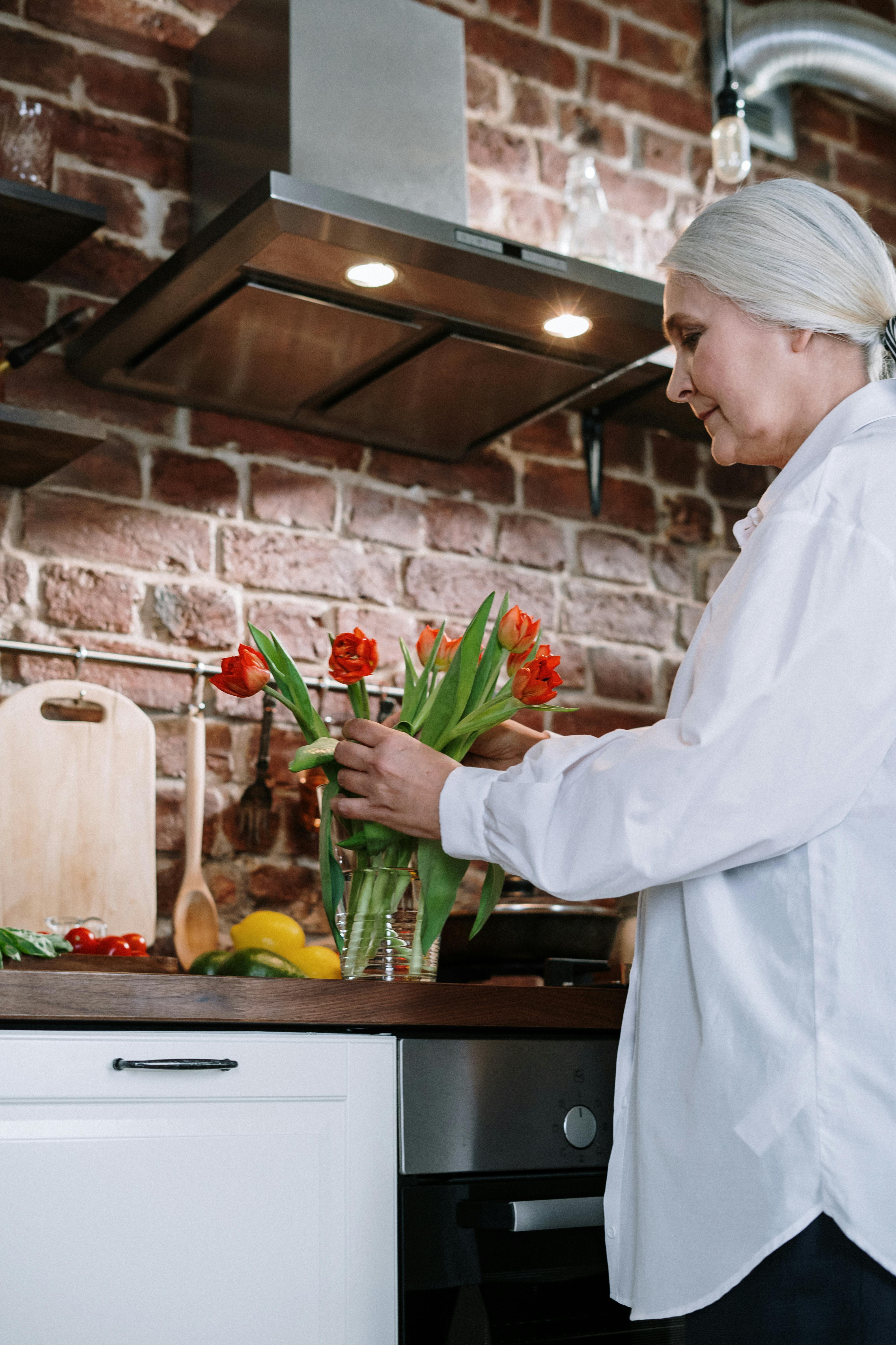 Femme arrangeant des fleurs dans un vase | Source : Pexels
