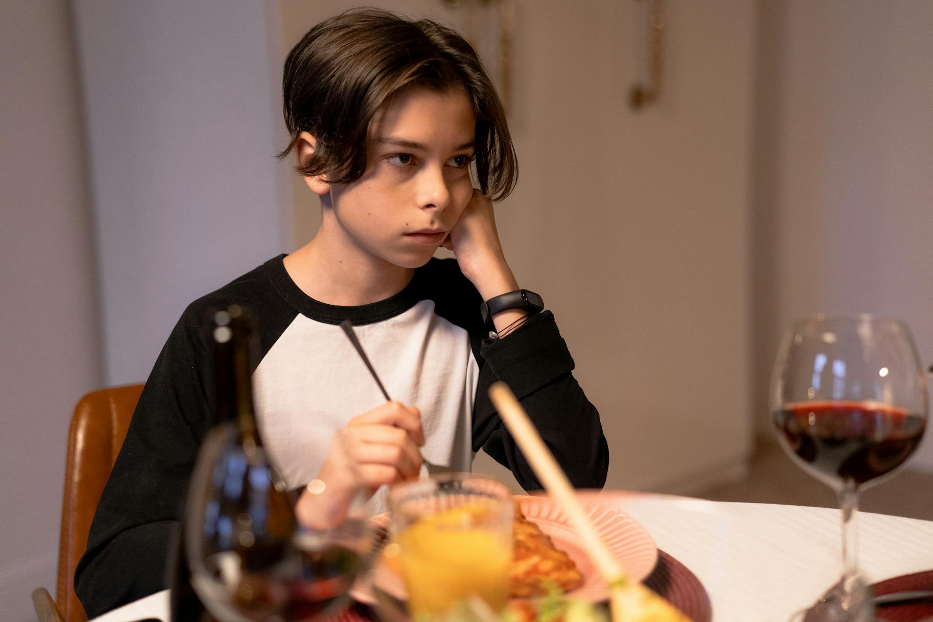 Un garçon triste à la table du dîner | Source : Pexels