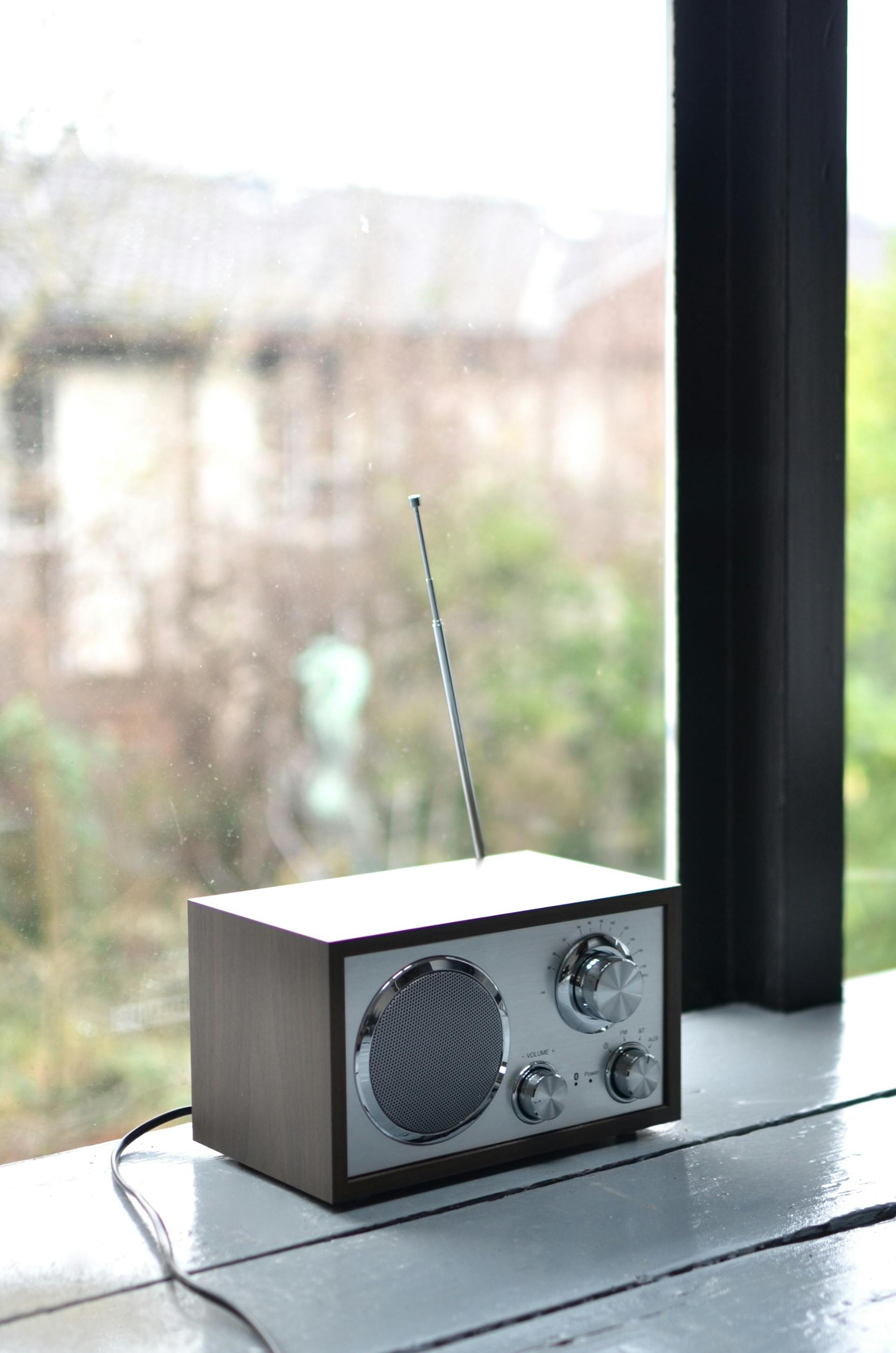 Un poste de radio portable moderne sur un rebord de fenêtre | Source : Pexels