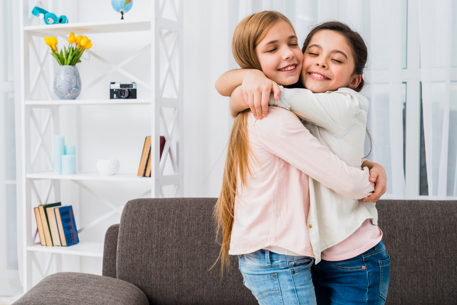 Deux filles souriantes qui se prennent dans les bras | Source : Freepik