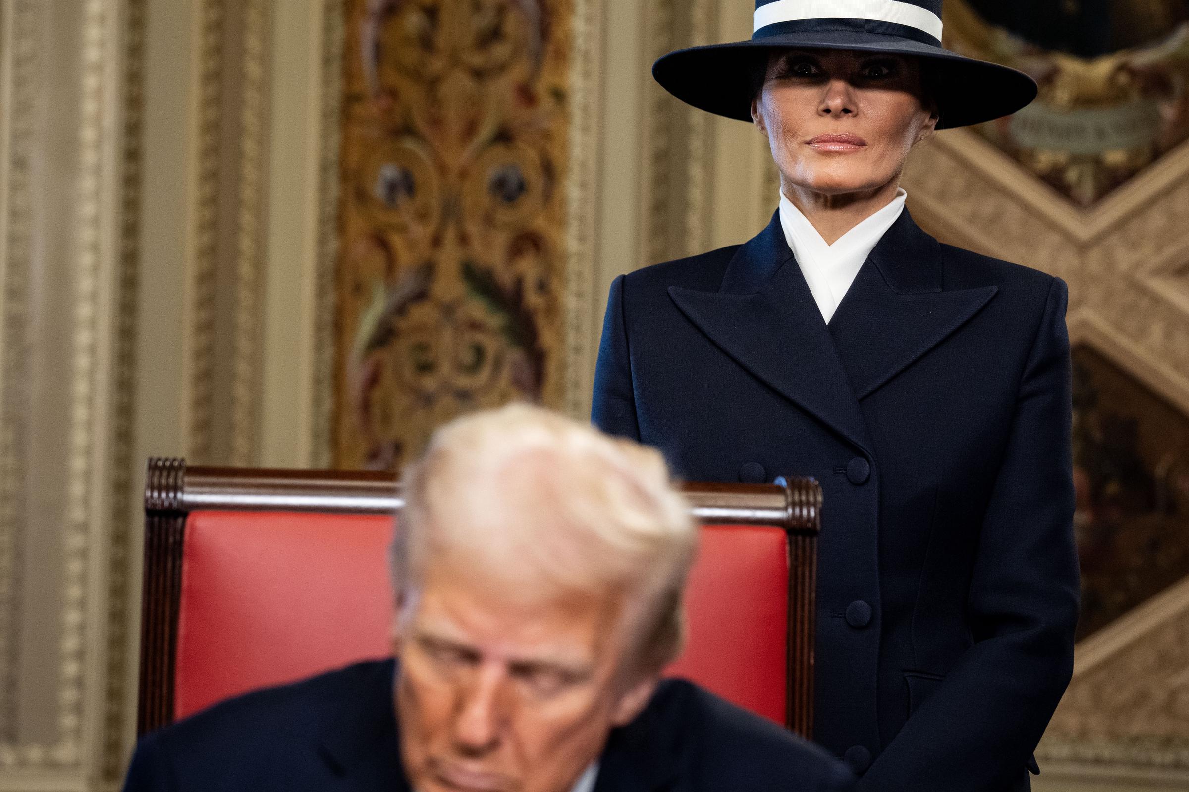 Le président Donald Trump signant des documents officiels dans la salle du président avec la première dame Melania Trump en arrière-plan, le 20 janvier 2025, au Capitole des États-Unis à Washington, D.C. | Source : Getty Images