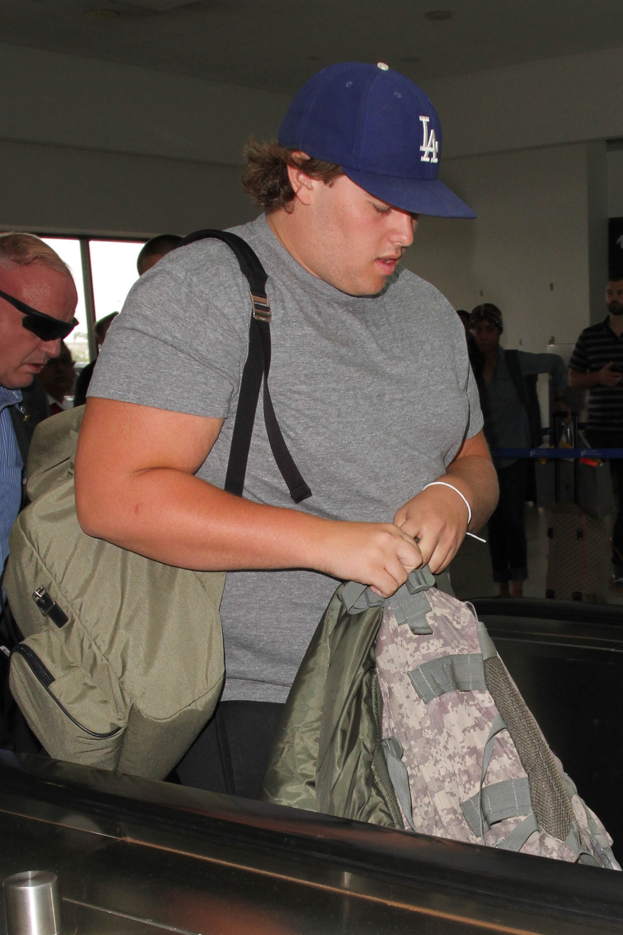Sur un autre cliché pris le même jour, Christopher marche à l'extérieur du terminal en tenue de sport décontractée, comprenant un short noir et des baskets grises. Sa casquette et sa coiffure lâche ajoutent à son look décontracté alors qu'il se déplace d'un pas décidé.