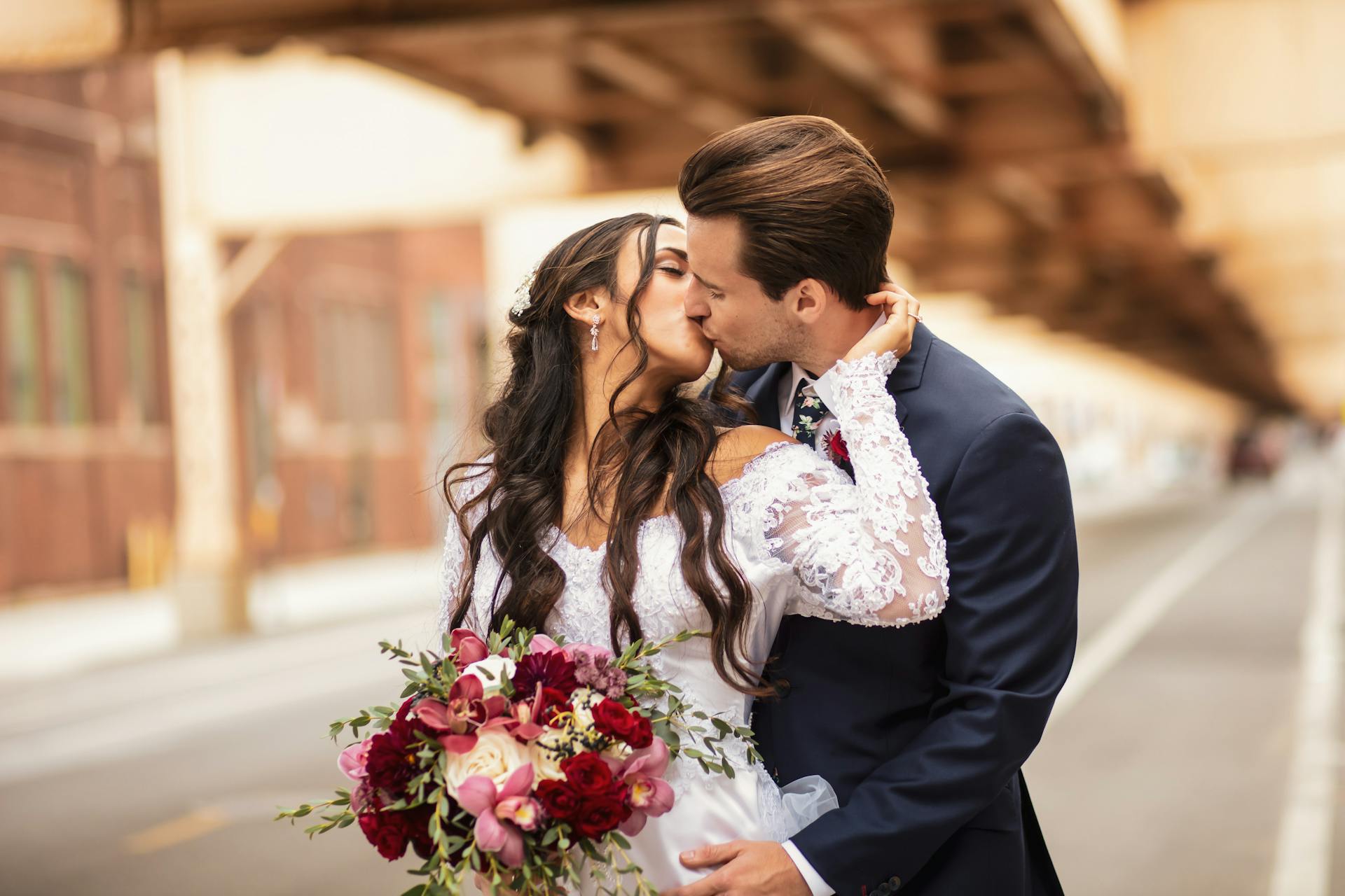 Un couple de jeunes mariés scellant leur amour par un baiser | Source : Pexels