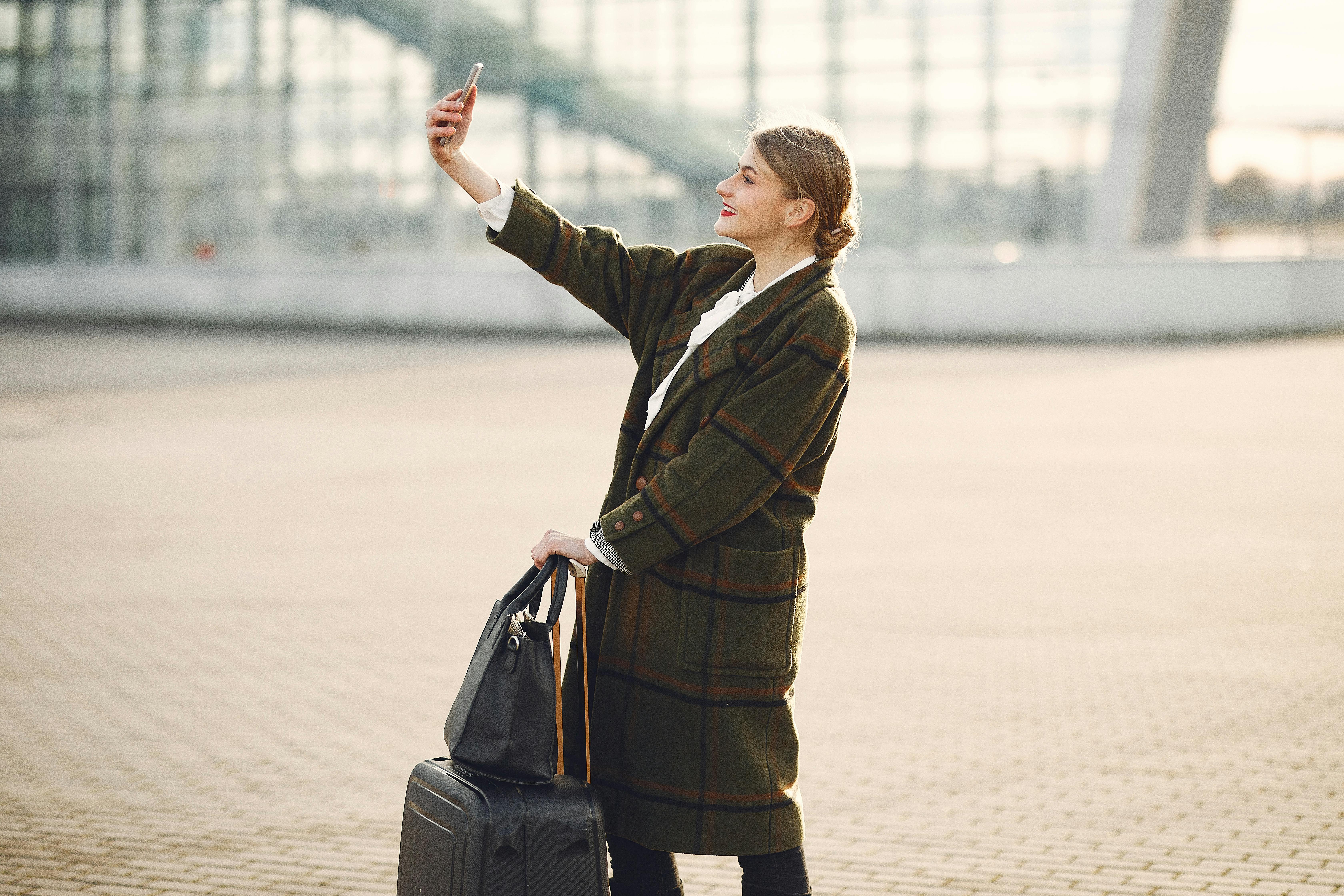 Une femme regarde son téléphone dans un aéroport | Source : Pexels