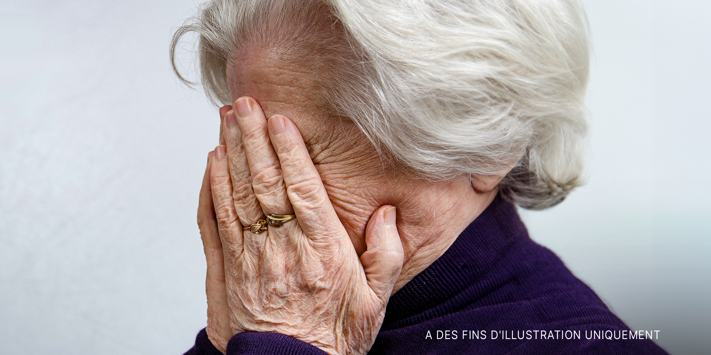 Une femme âgée se couvrant le visage avec ses mains | Source : Shutterstock
