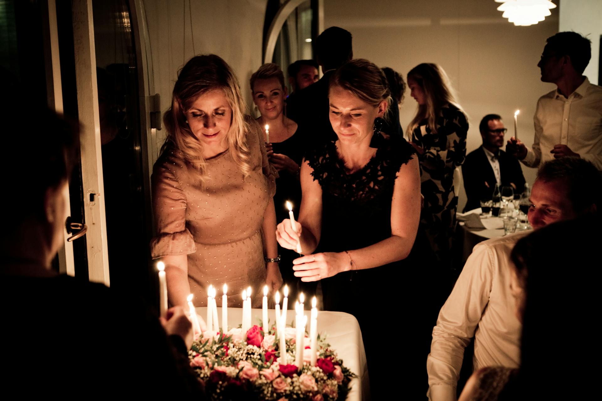 Deux femmes tenant des bougies lors d'une fête d'anniversaire | Source : Pexels
