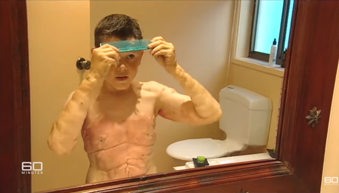 Tomm Tennent se coiffe en se regardant dans le miroir. | Source : YouTube.com/60 Minutes Australia