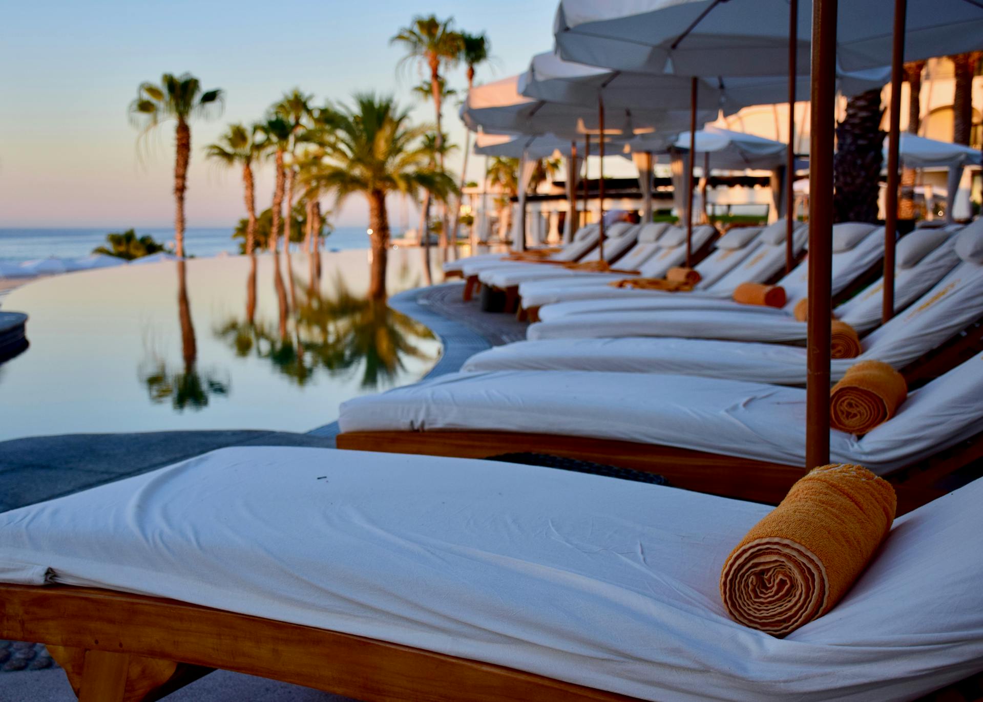 Chaises longues disposées dans un cadre extérieur confortable avec vue sur les eaux sereines | Source : Pexels