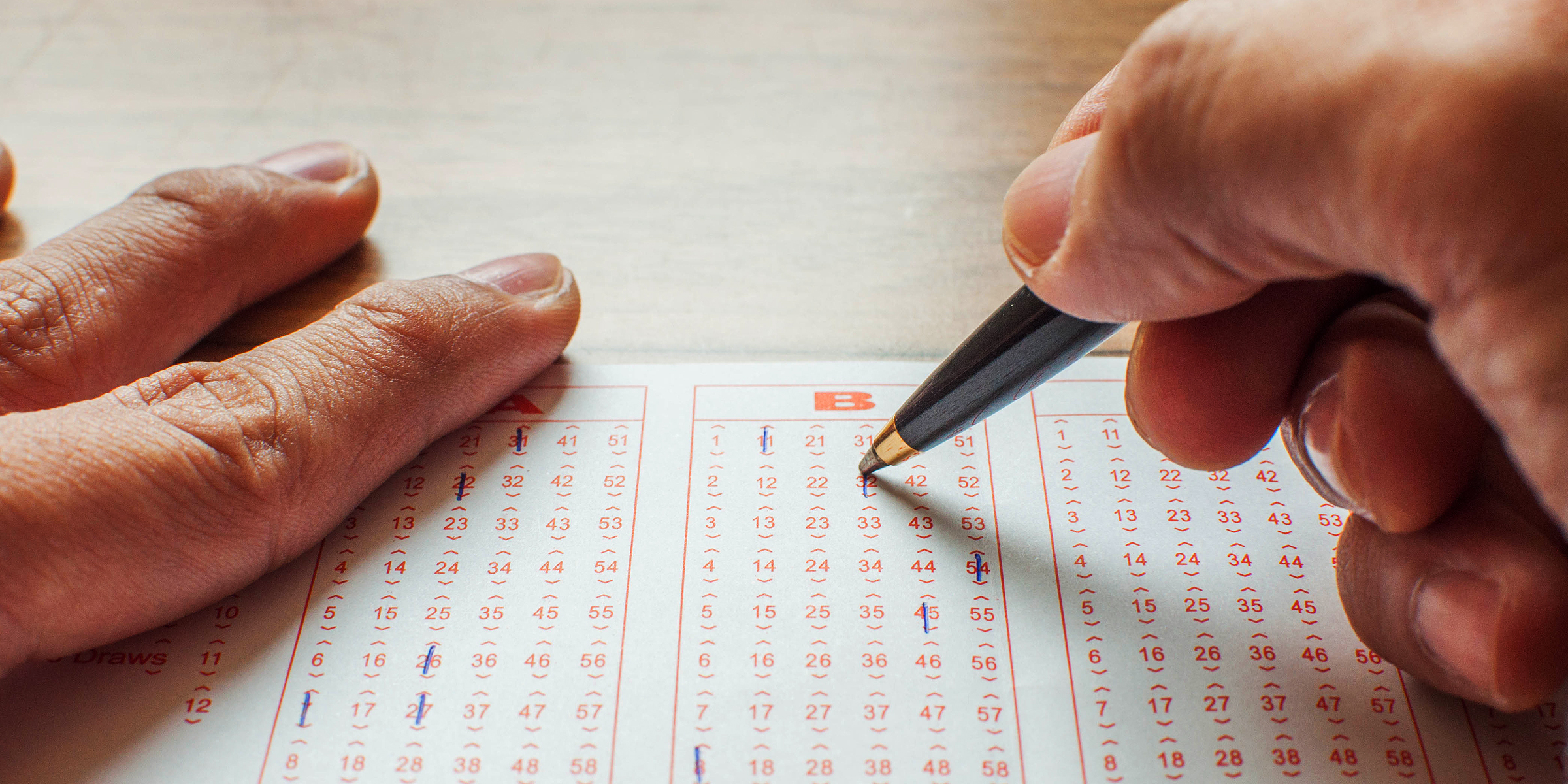 Une personne sélectionnant les numéros d'un billet de loterie | Source : Getty Images
