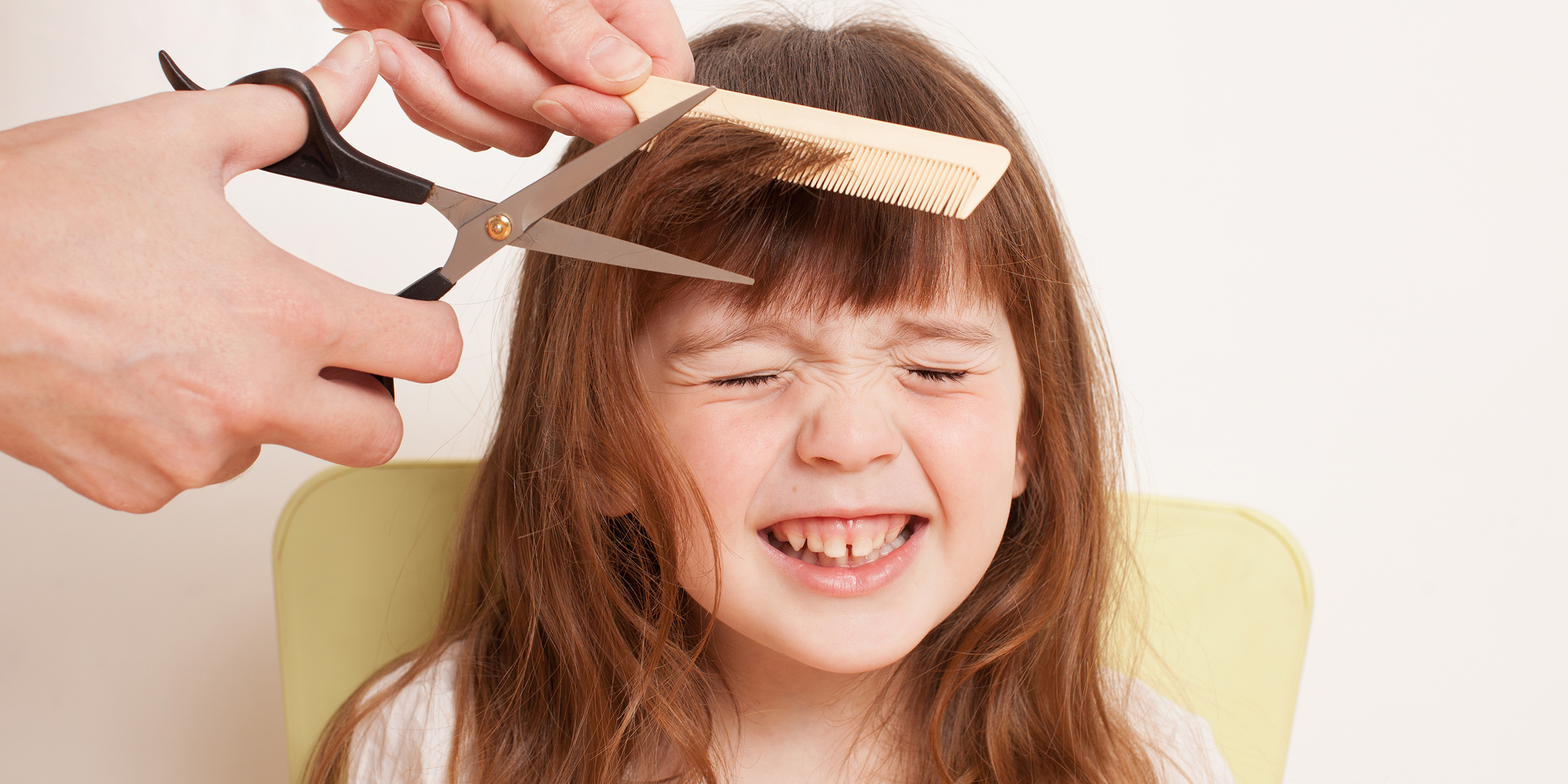 Une personne qui coupe les cheveux d'une petite fille | Source : Shutterstock