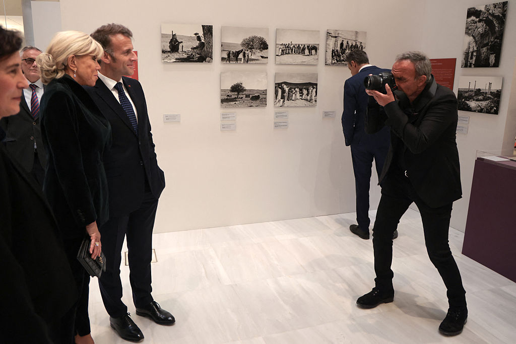 Le journaliste et animateur franco-grec Nikos Aliagas prend une photo du président français Emmanuel Macron et de son épouse Brigitte Macron (à gauche) alors qu'ils visitent l'exposition au Centre culturel de la Fondation Stavros Niarchos à Athènes, le 25 avril 2026 I Source : Getty Images
