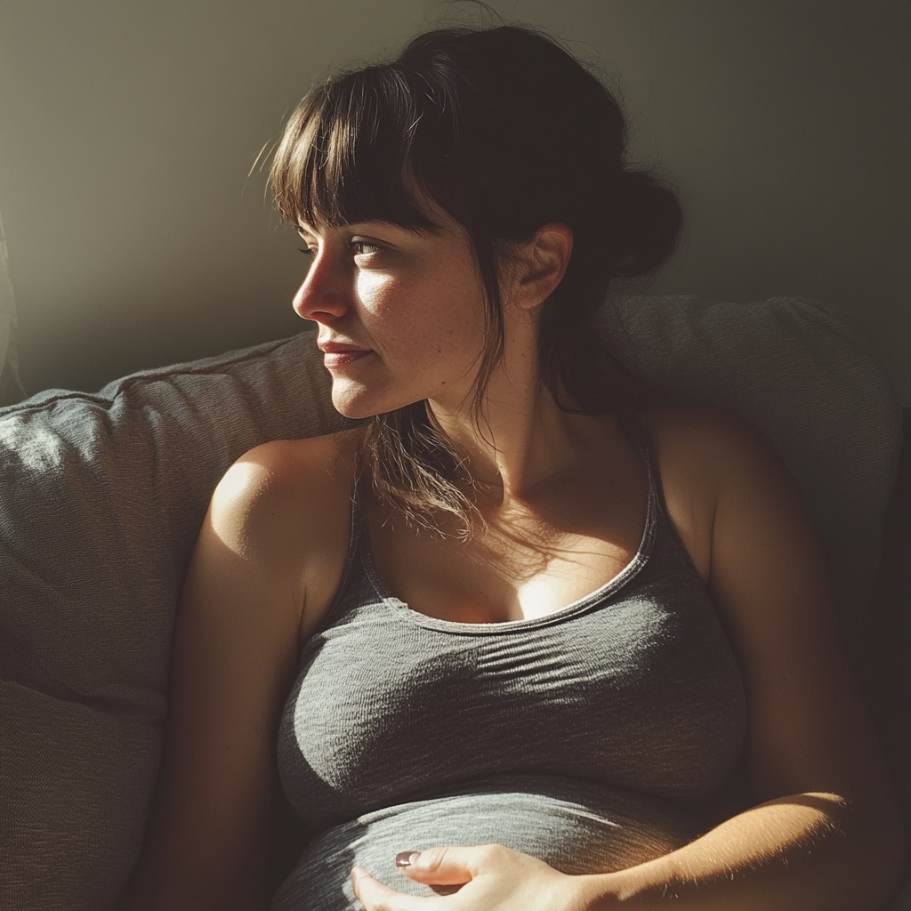 Une femme enceinte assise sur un canapé | Source : Midjourney