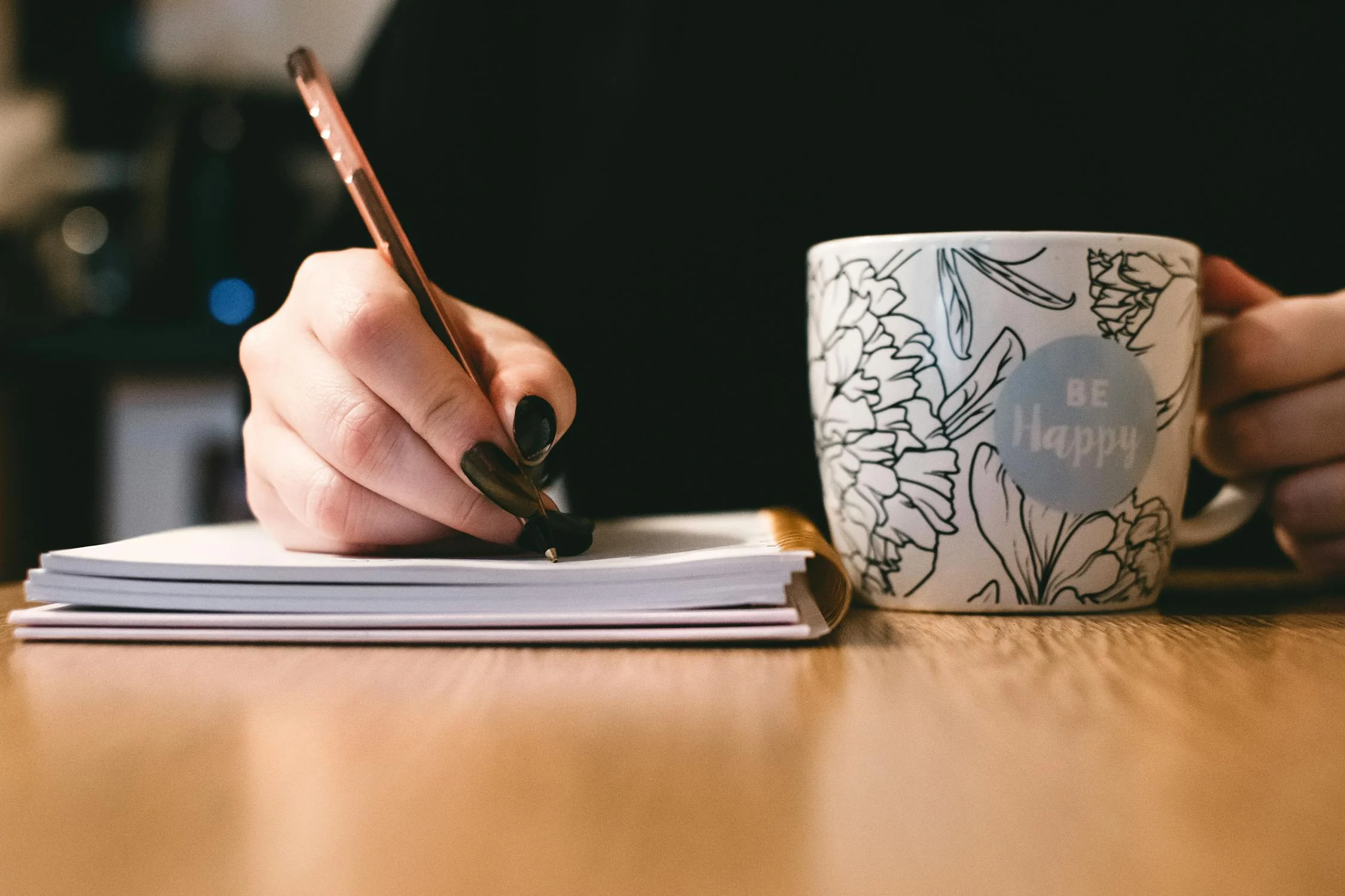 A woman writing on a notepad | Source: Pexels