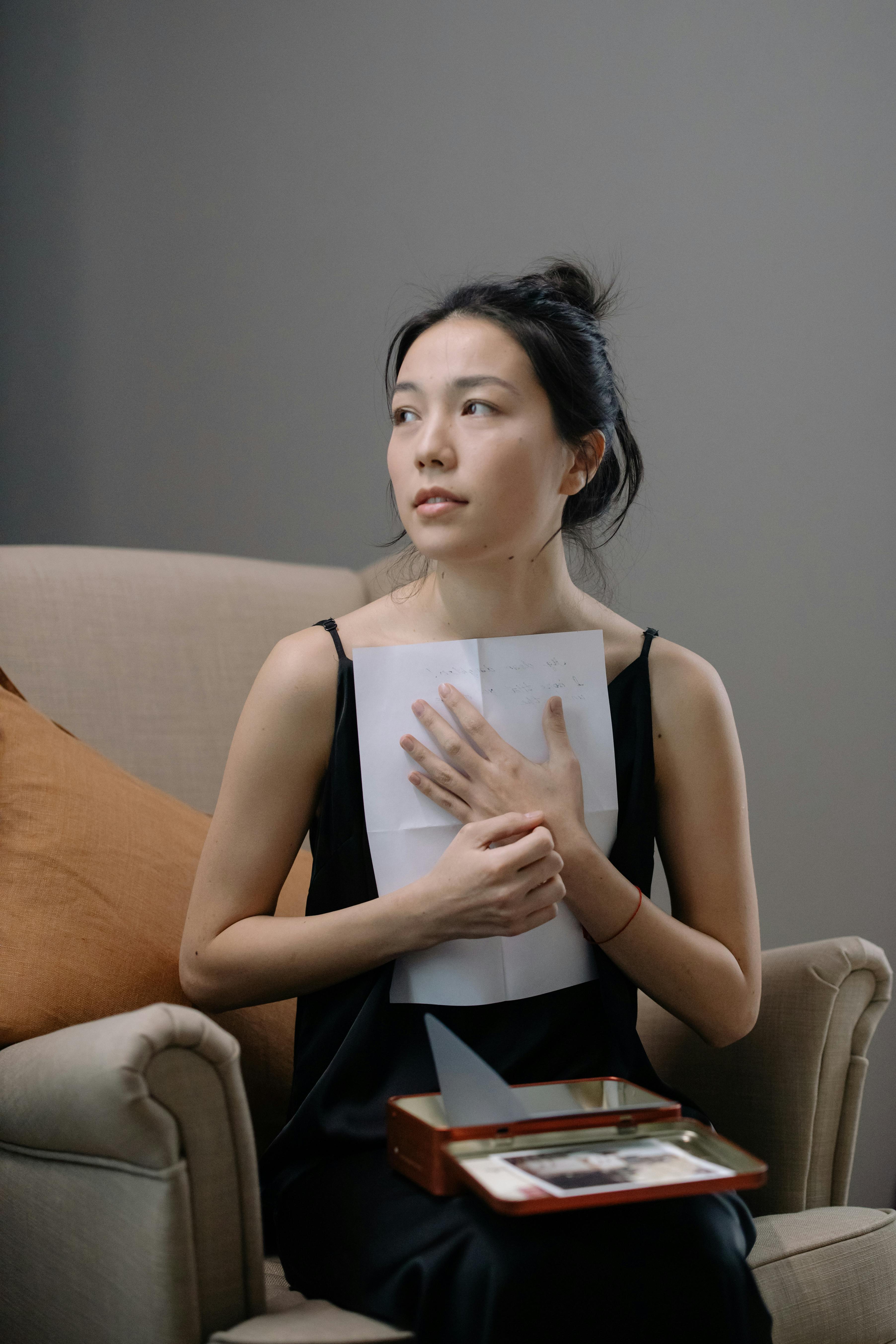 Une femme tient une lettre contre sa poitrine | Source : Pexels