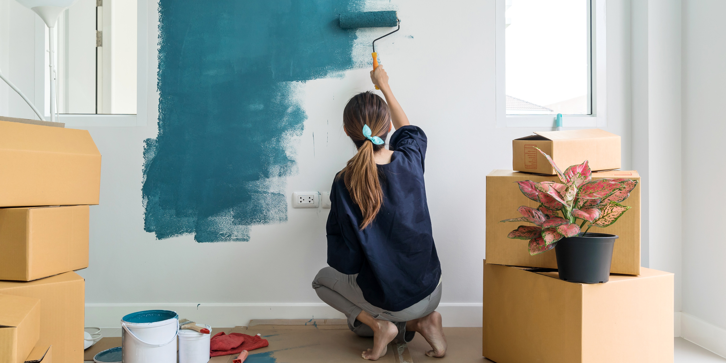 Une femme en train de peindre un mur | Source : Shutterstock