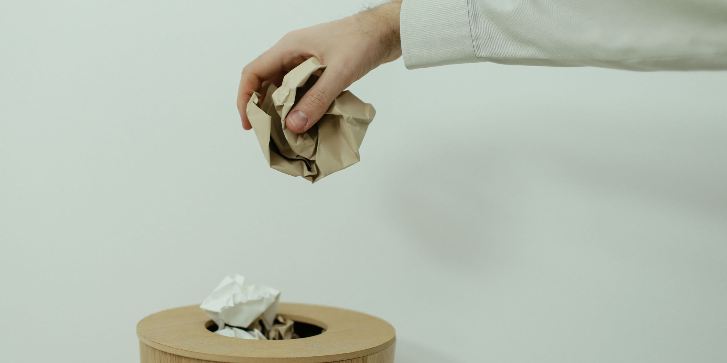 Une personne qui jette du papier dans une poubelle | Source : Pexels