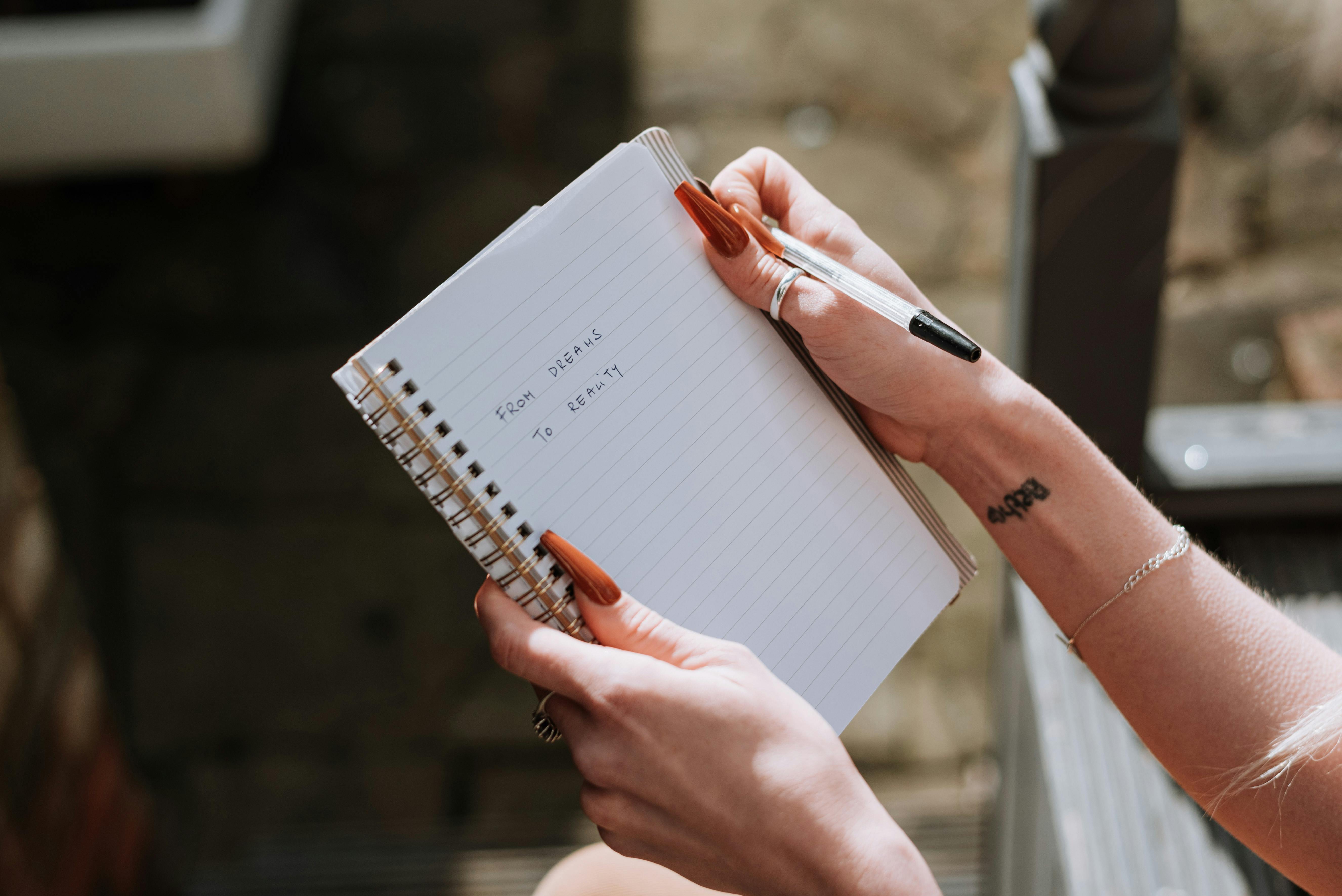 Une femme brandissant un cahier | Source : Pexels