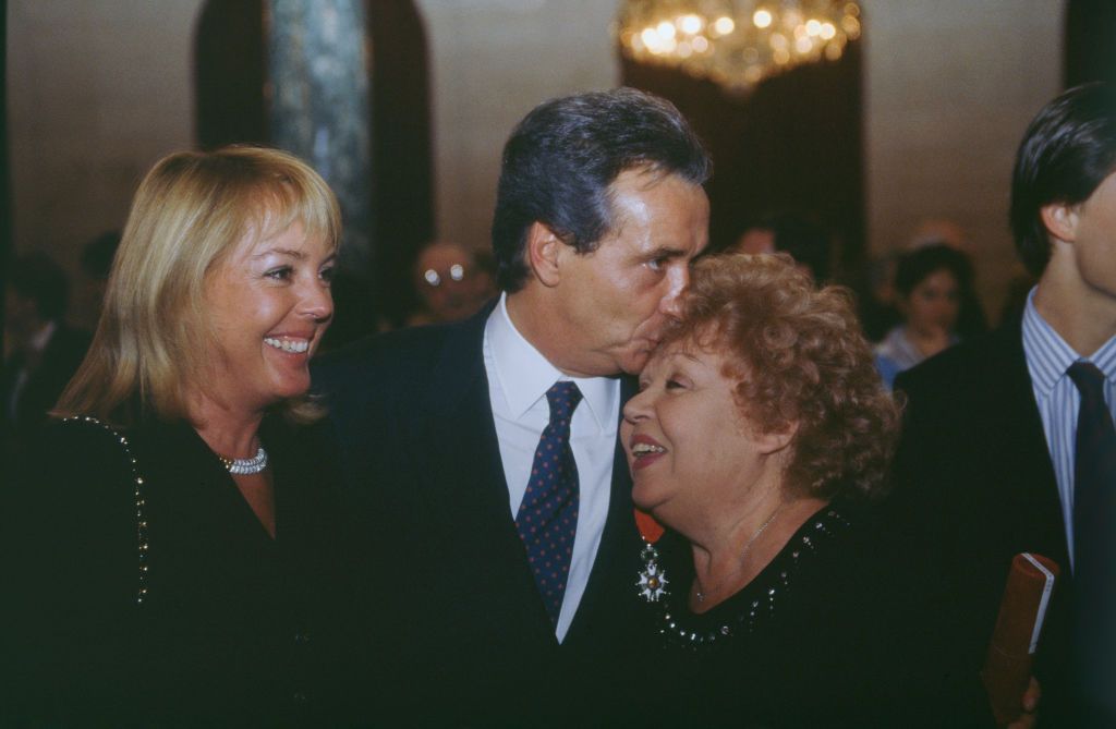 Le chanteur Michel Sardou fait un bisou à sa maman Jackie Sardou | Photo : Getty Images