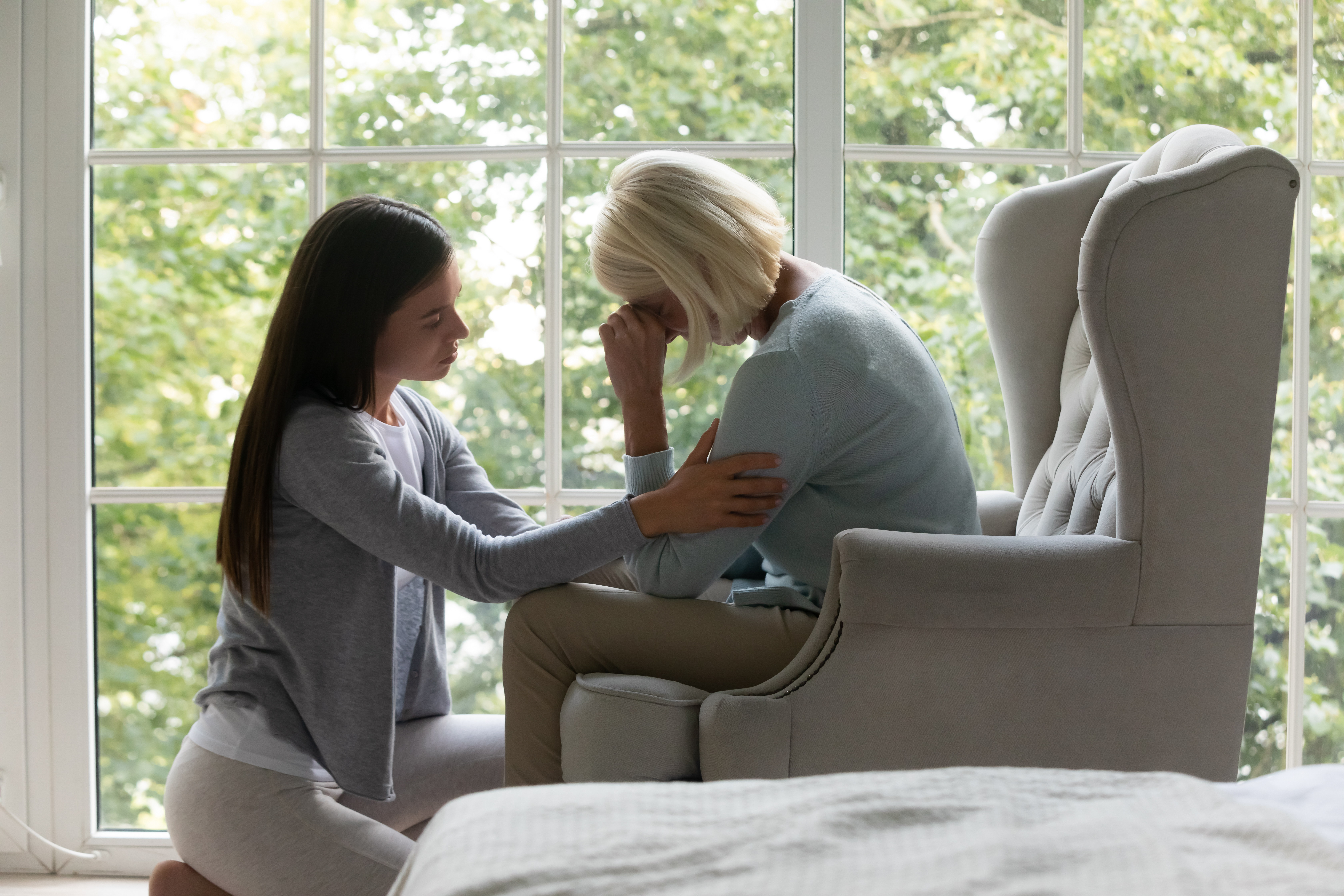 Une jeune femme réconforte sa mère âgée déprimée | Source : Shutterstock