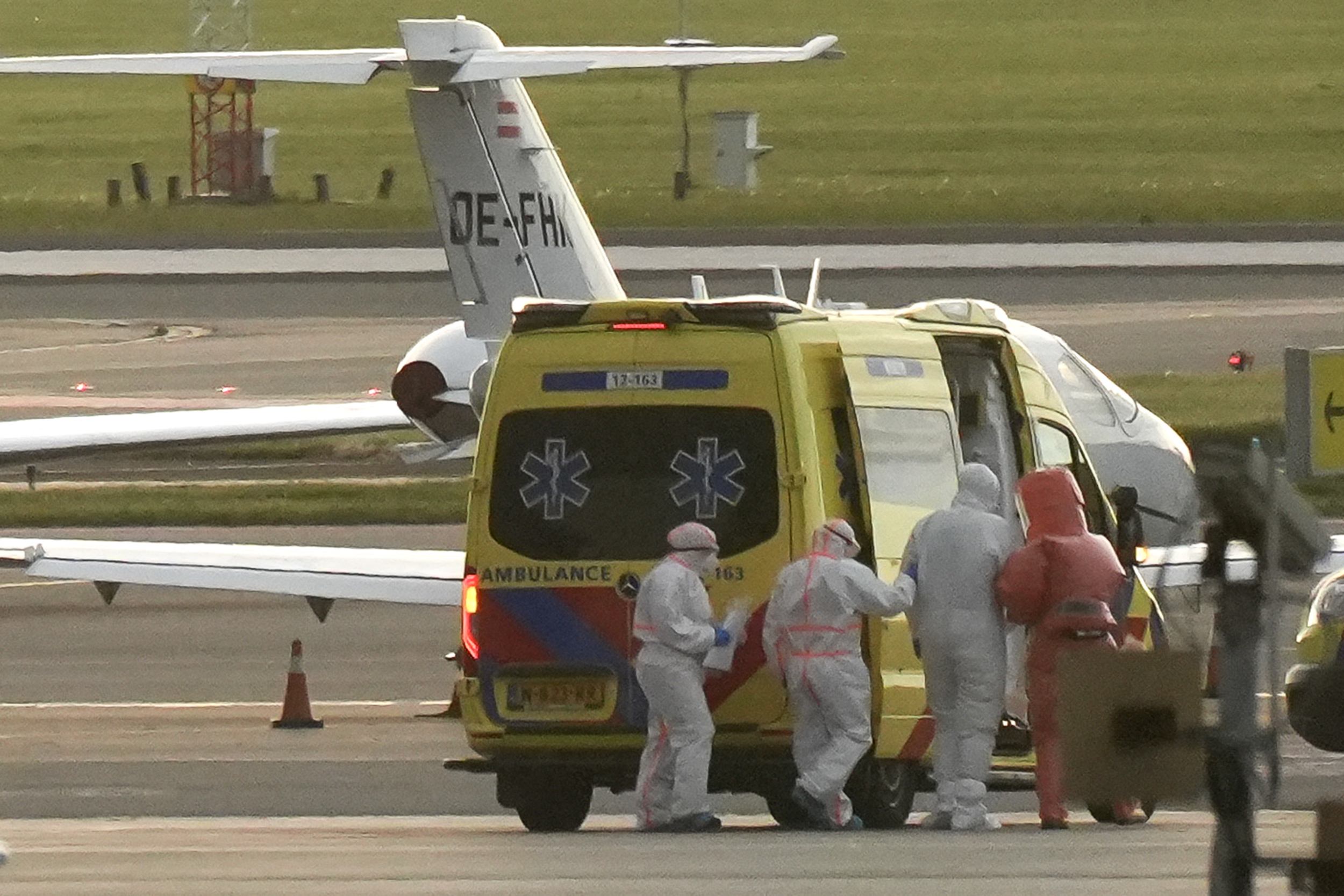 Une personne vêtue d'une combinaison de protection est escortée vers une ambulance depuis un avion sanitaire qui aurait transporté certains passagers du paquebot MV Hondius, soupçonnés d'être infectés par le hantavirus, à l'aéroport de Schiphol, près d'Amsterdam, le 6 mai 2026. | Source : Getty Images