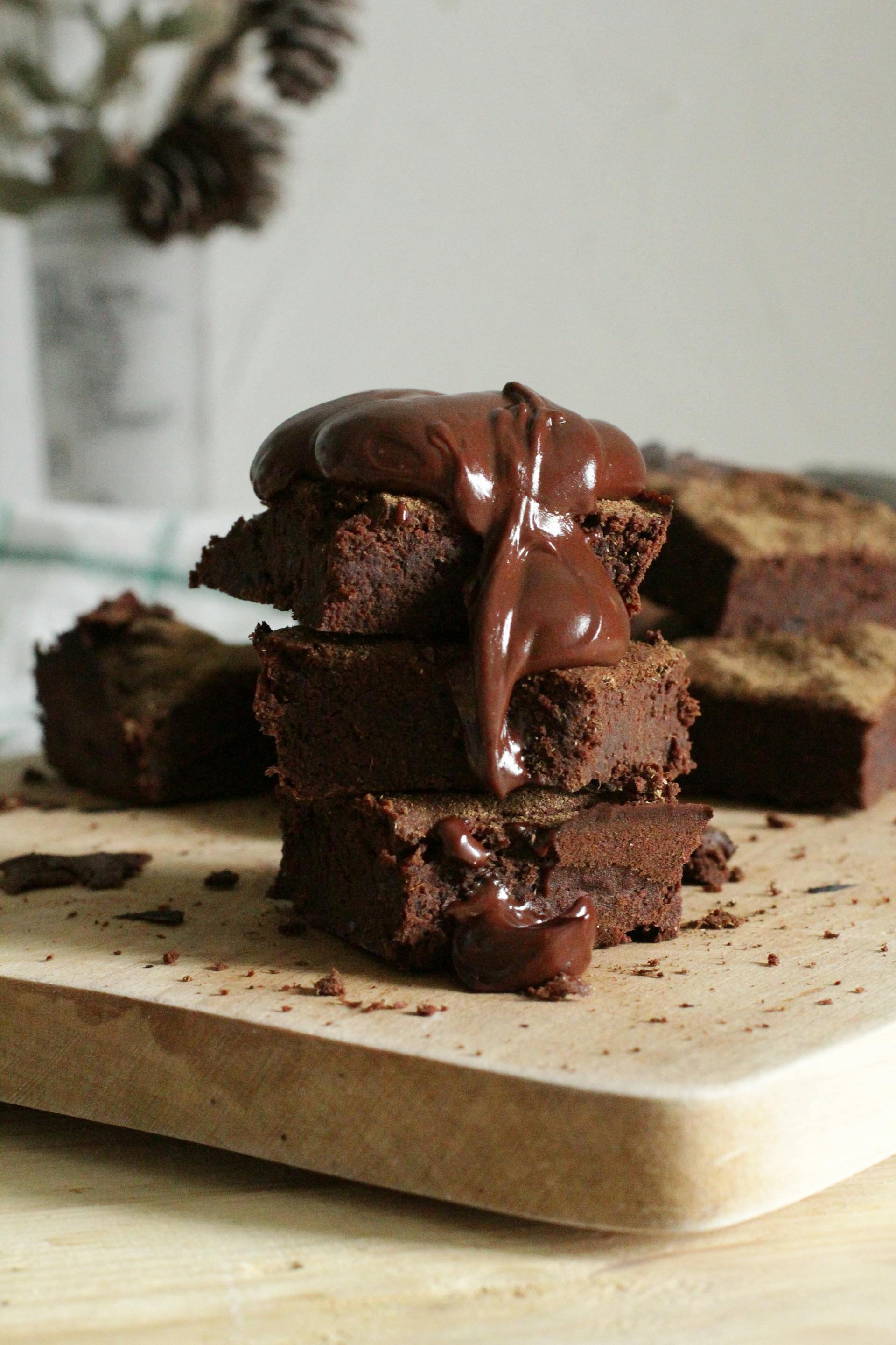 Gros plan sur des brownies empilés sur une planche à découper | Source : Pexels