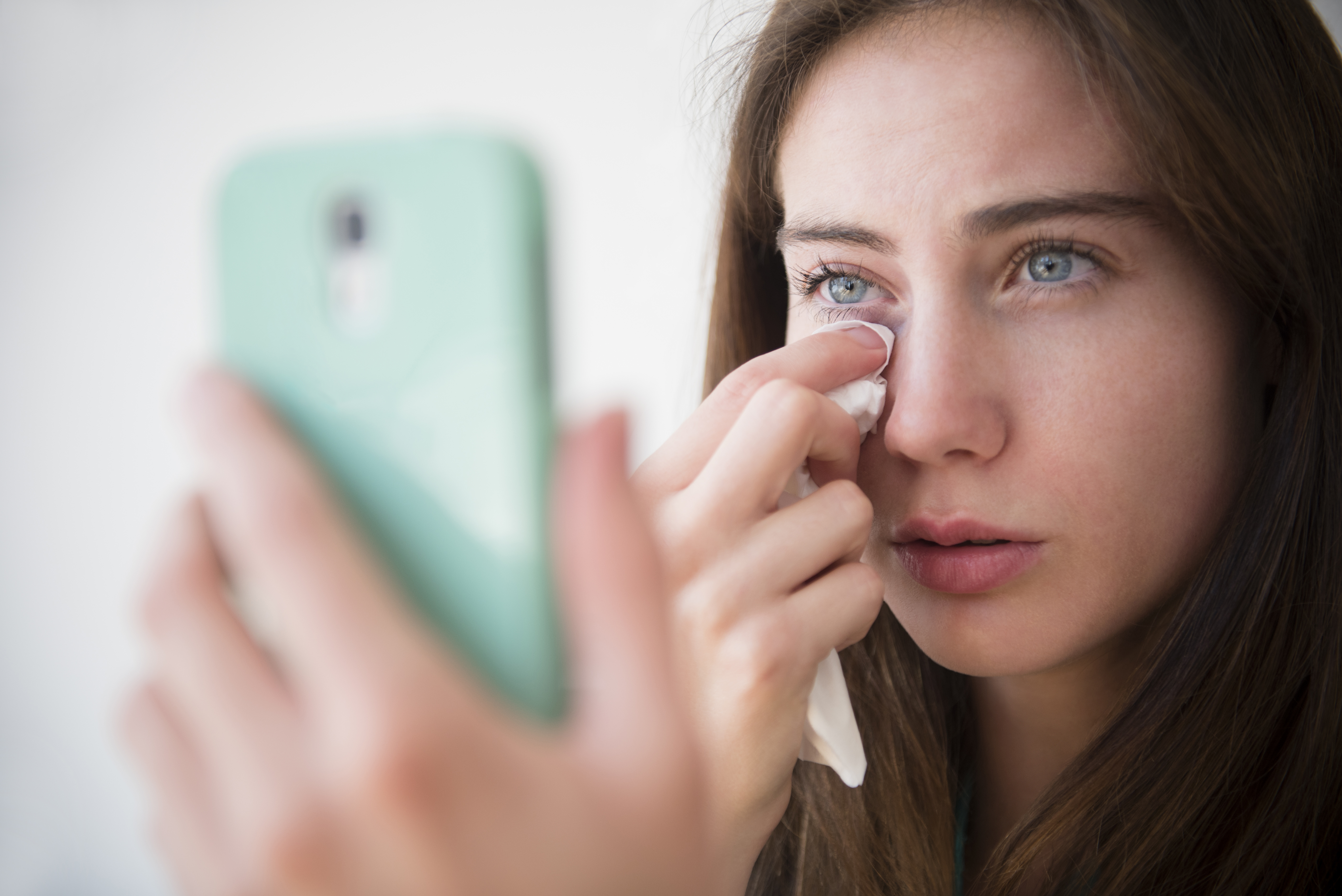 Une femme essuie ses larmes pendant un appel téléphonique | Source : Getty Images