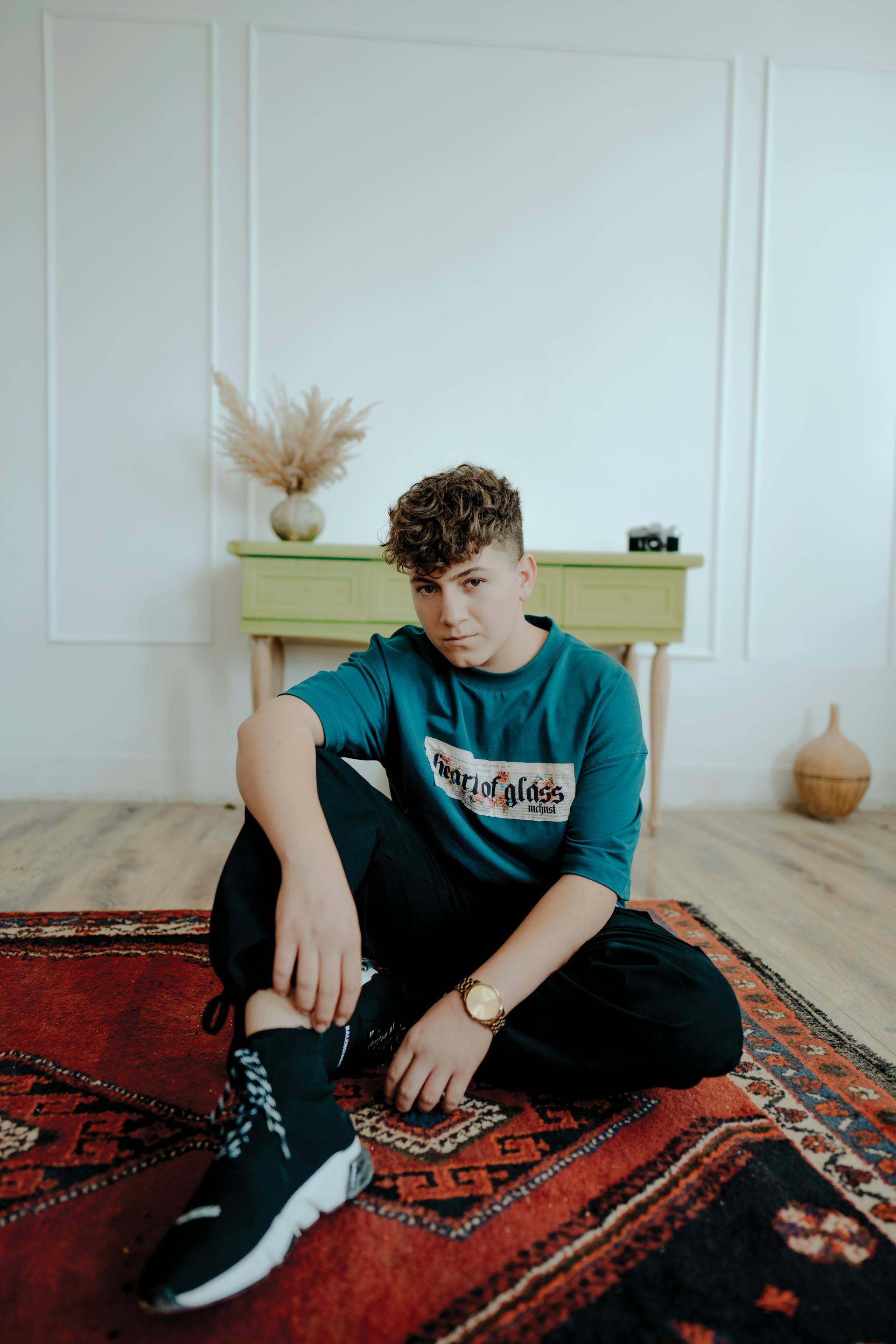 Un adolescent assis sur un tapis | Source : Pexels