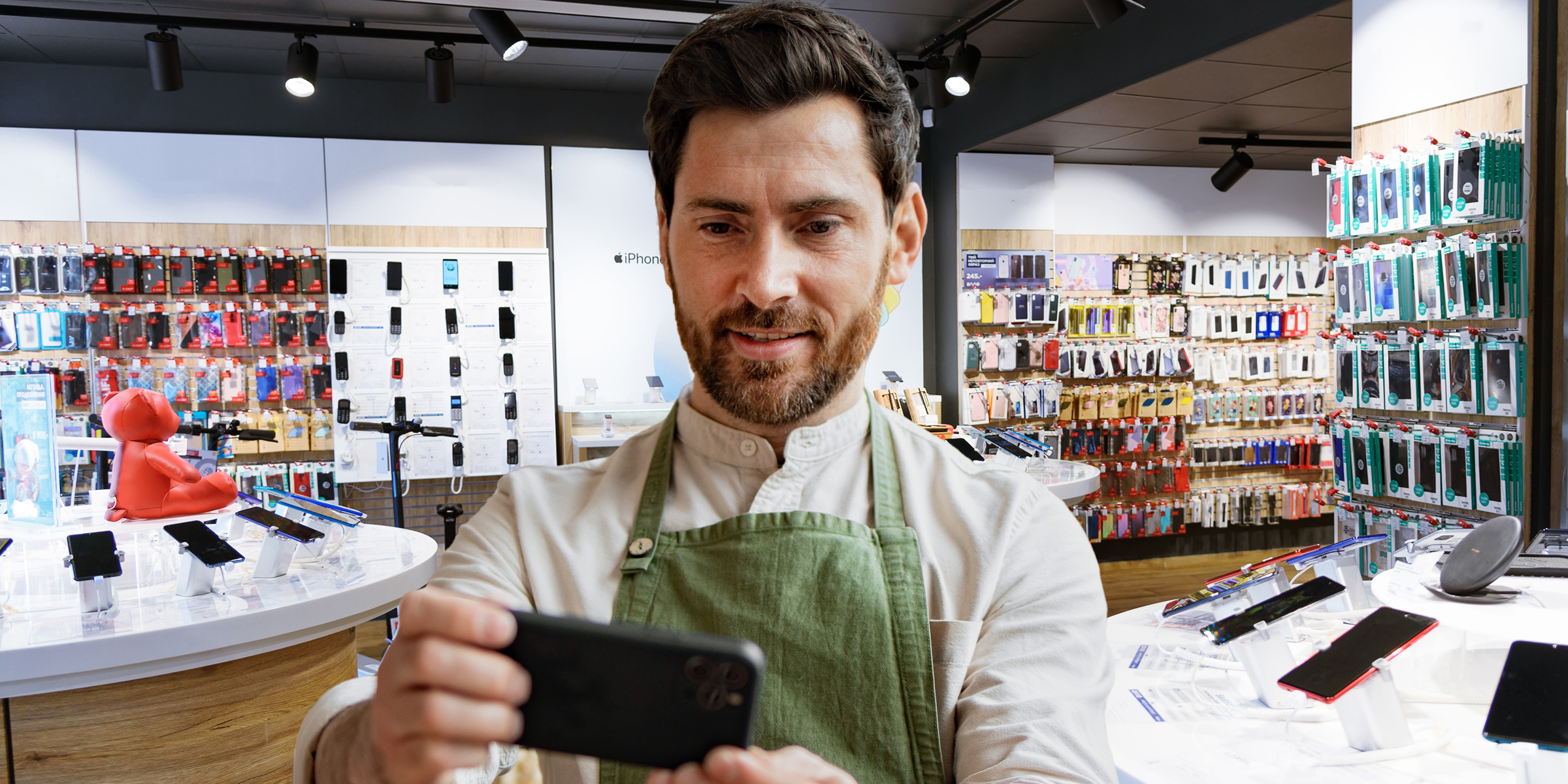 Un homme regarde un téléphone dans un magasin | Source : Shutterstock